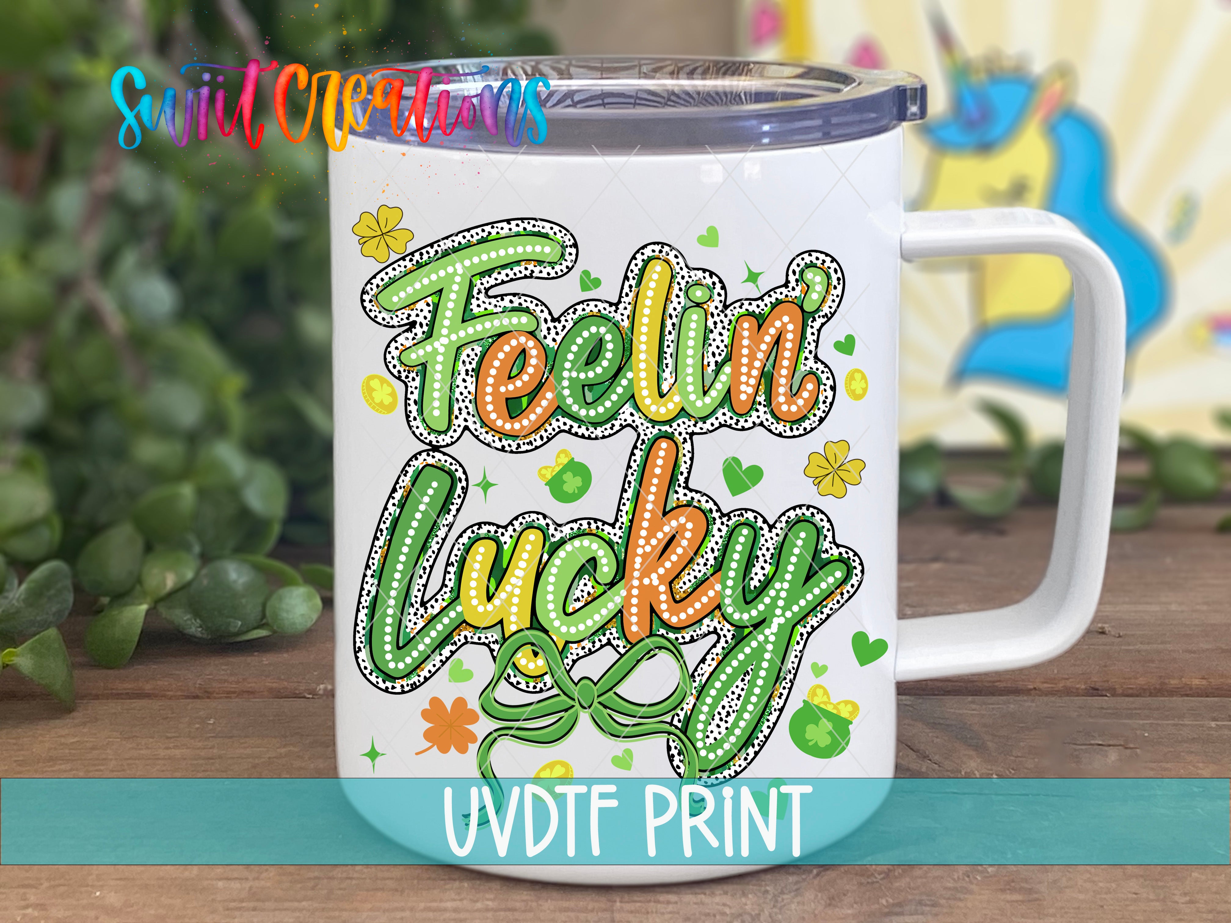 A white mug with a colorful design featuring the text "Feelin' Lucky" and various decorative elements such as hearts, flowers, and leaves.