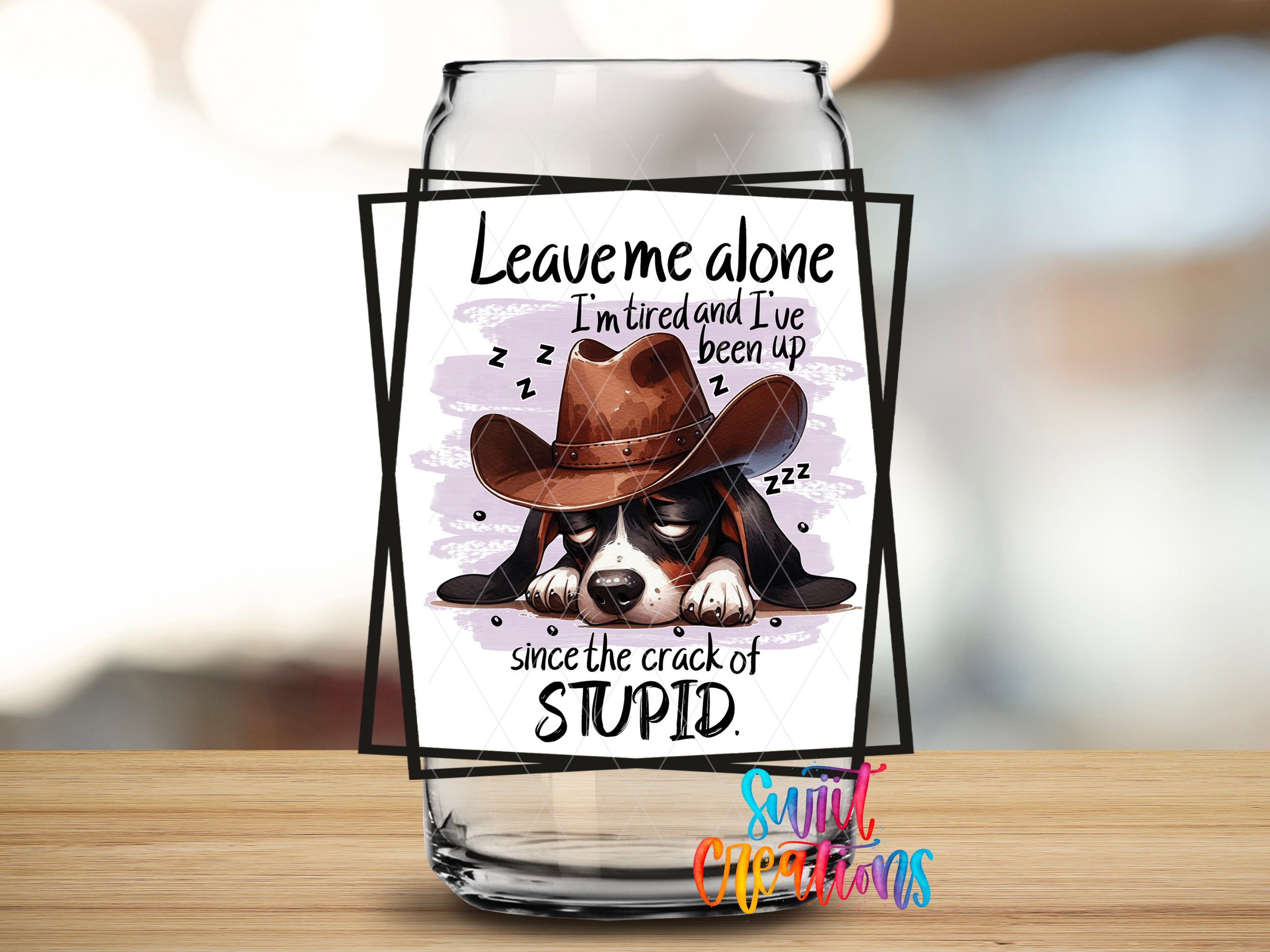 a glass jar with a cartoon image of a dog wearing a cowboy hat and sleeping, accompanied by the text "Leave me alone I'm tired and I've been up since the crack of stupid".