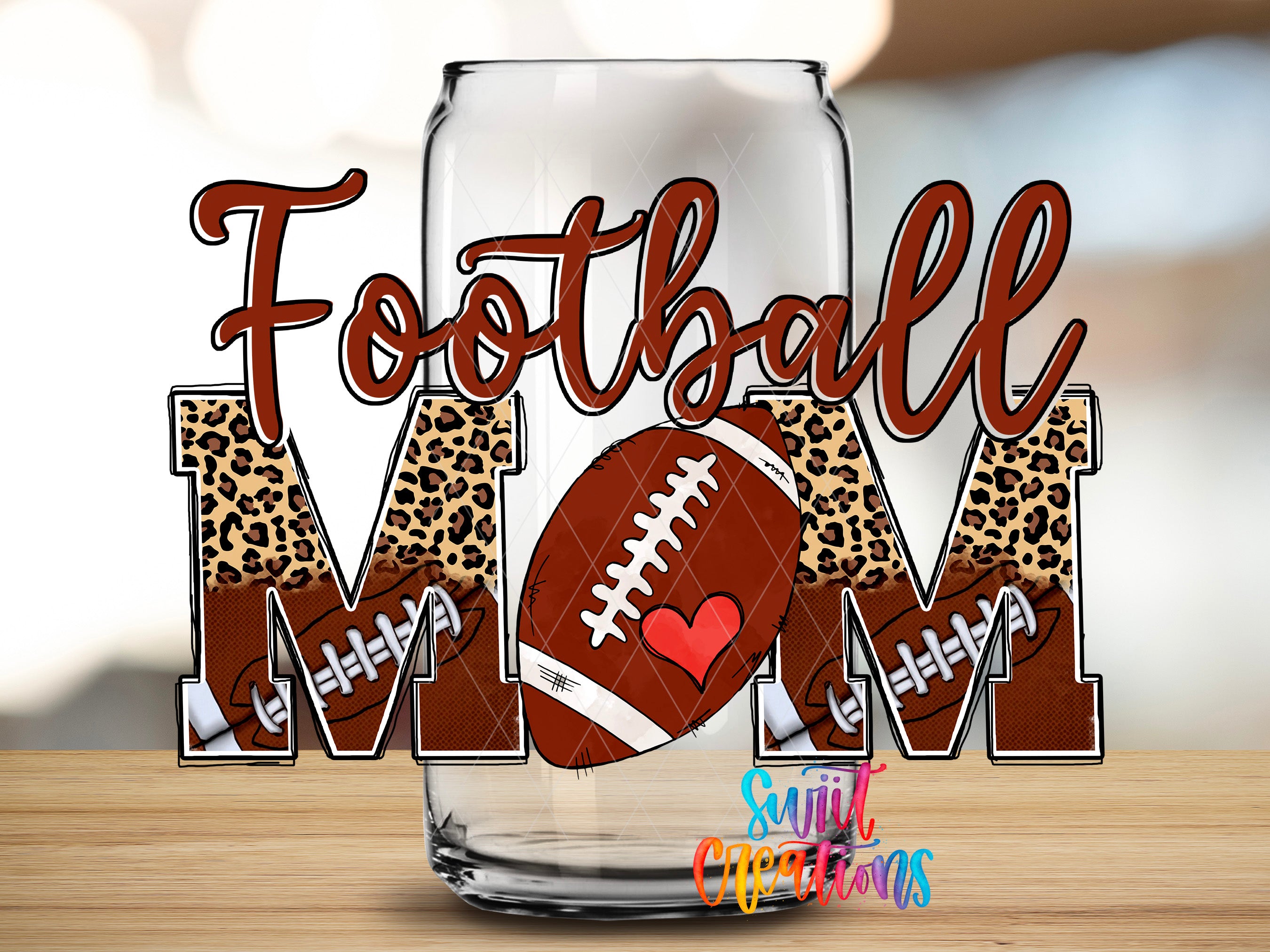 A glass can with the word "Football Mom" written on it, along with a football graphic and leopard print elements.