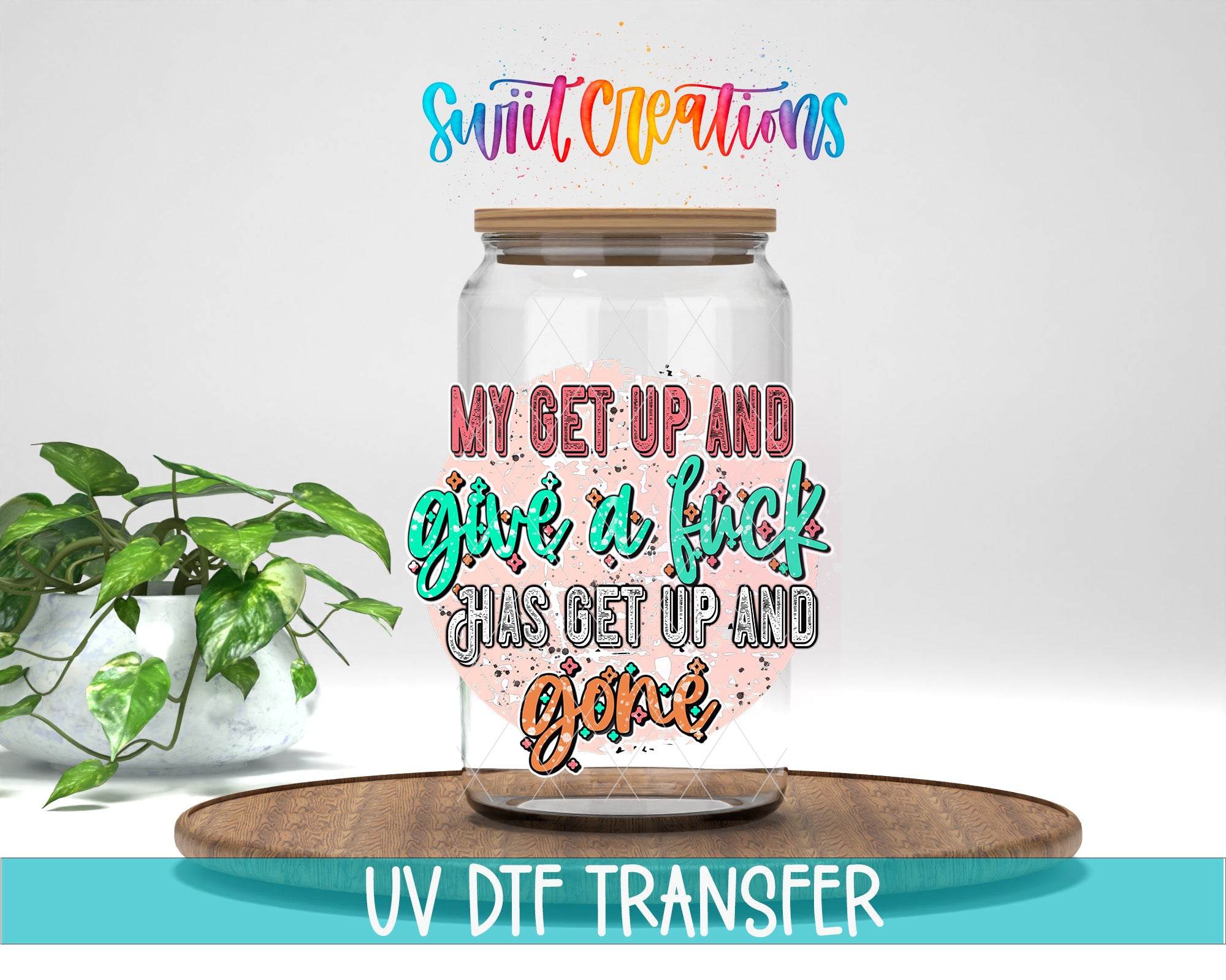 a glass jar with a colorful, artistic design on it, placed on a wooden surface. The jar has a lid and is surrounded by a potted plant. The text on the jar reads "My get up and give a fuck has got up and gone".