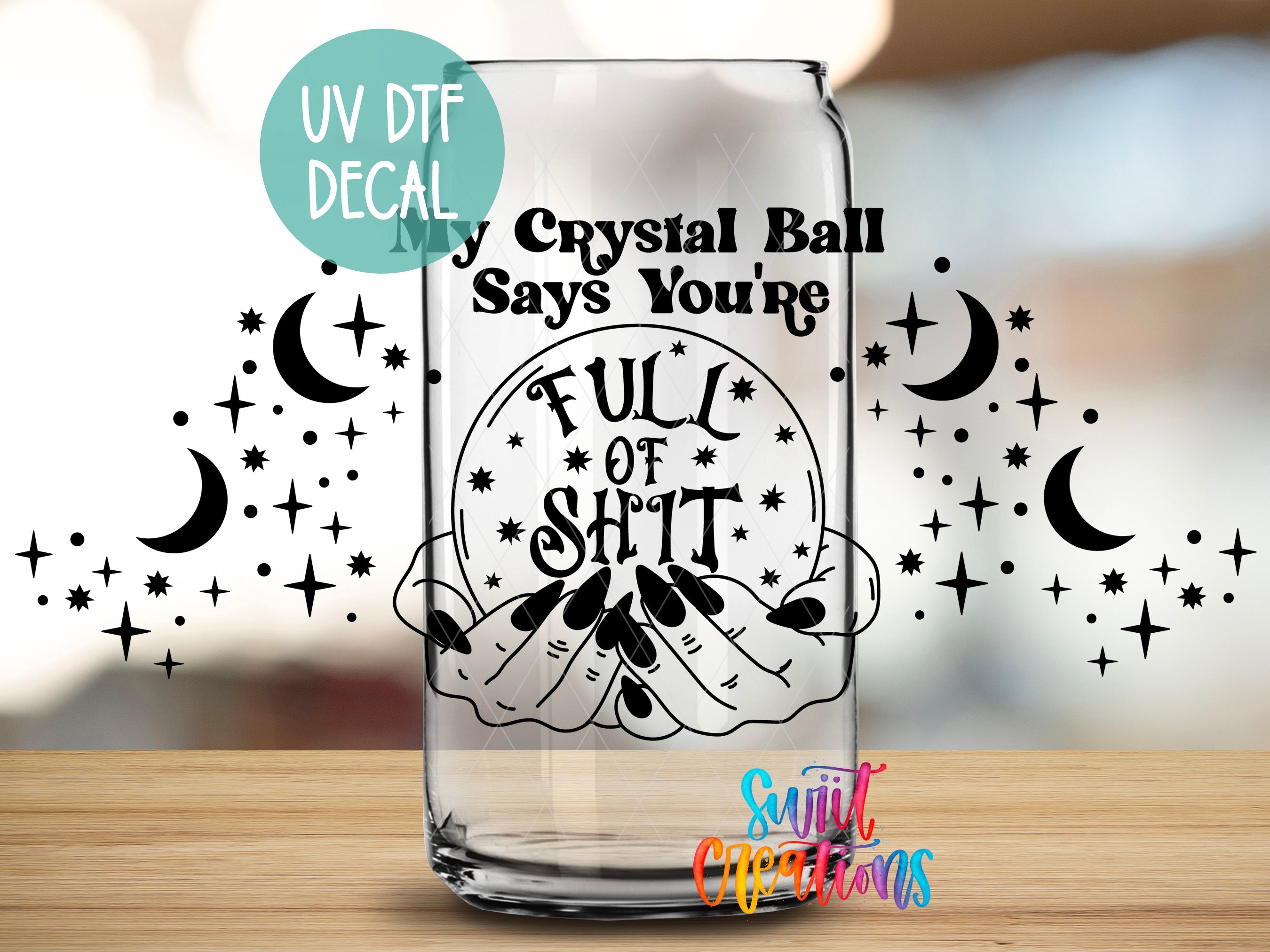 a glass with a sticker on it, which contains a humorous text and a design with stars and crescent moons.