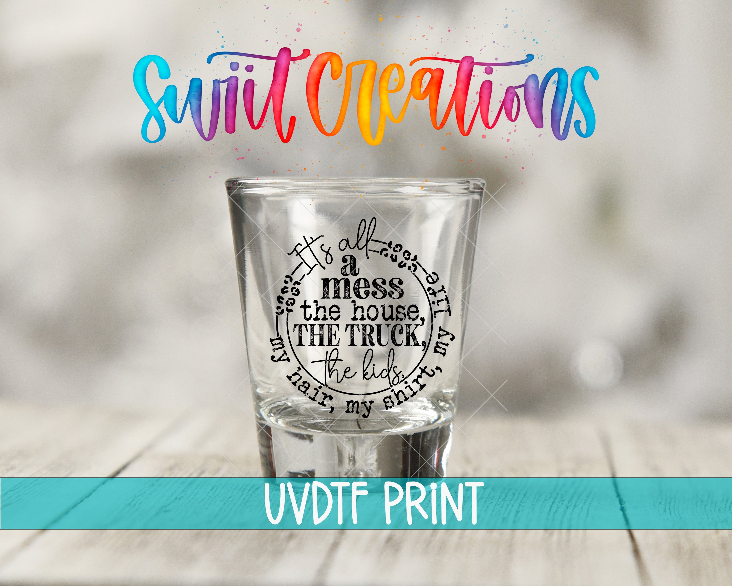 a shot glass with a printed text design on it, placed on a wooden surface.