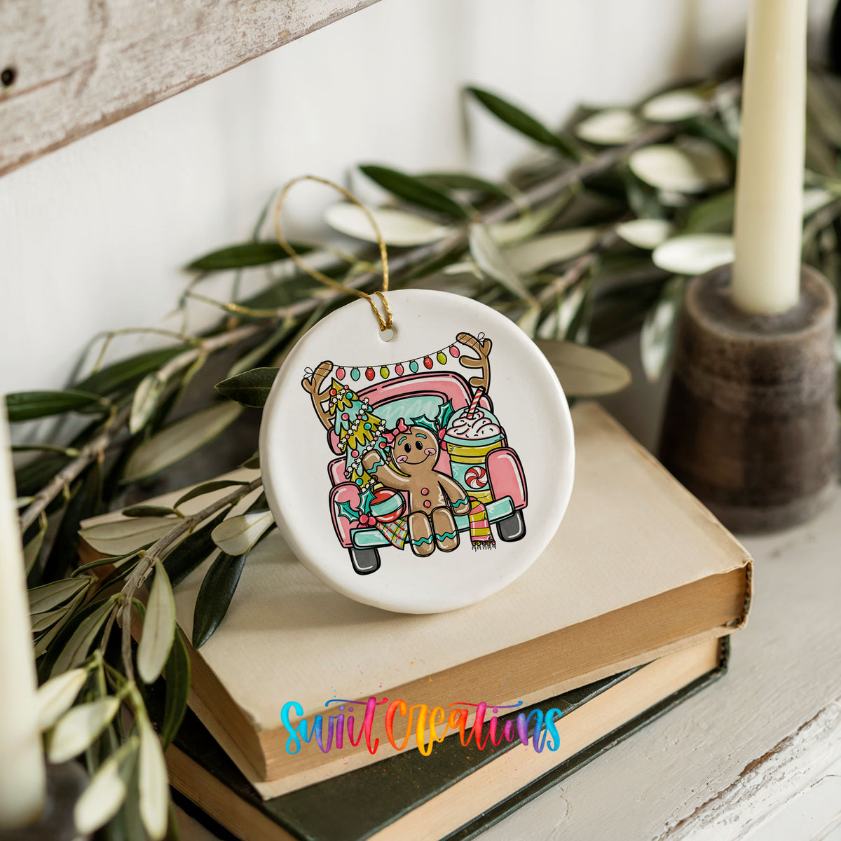 A ceramic ornament featuring a gingerbread man sitting in a pink truck, surrounded by Christmas decorations, placed on top of a stack of books.