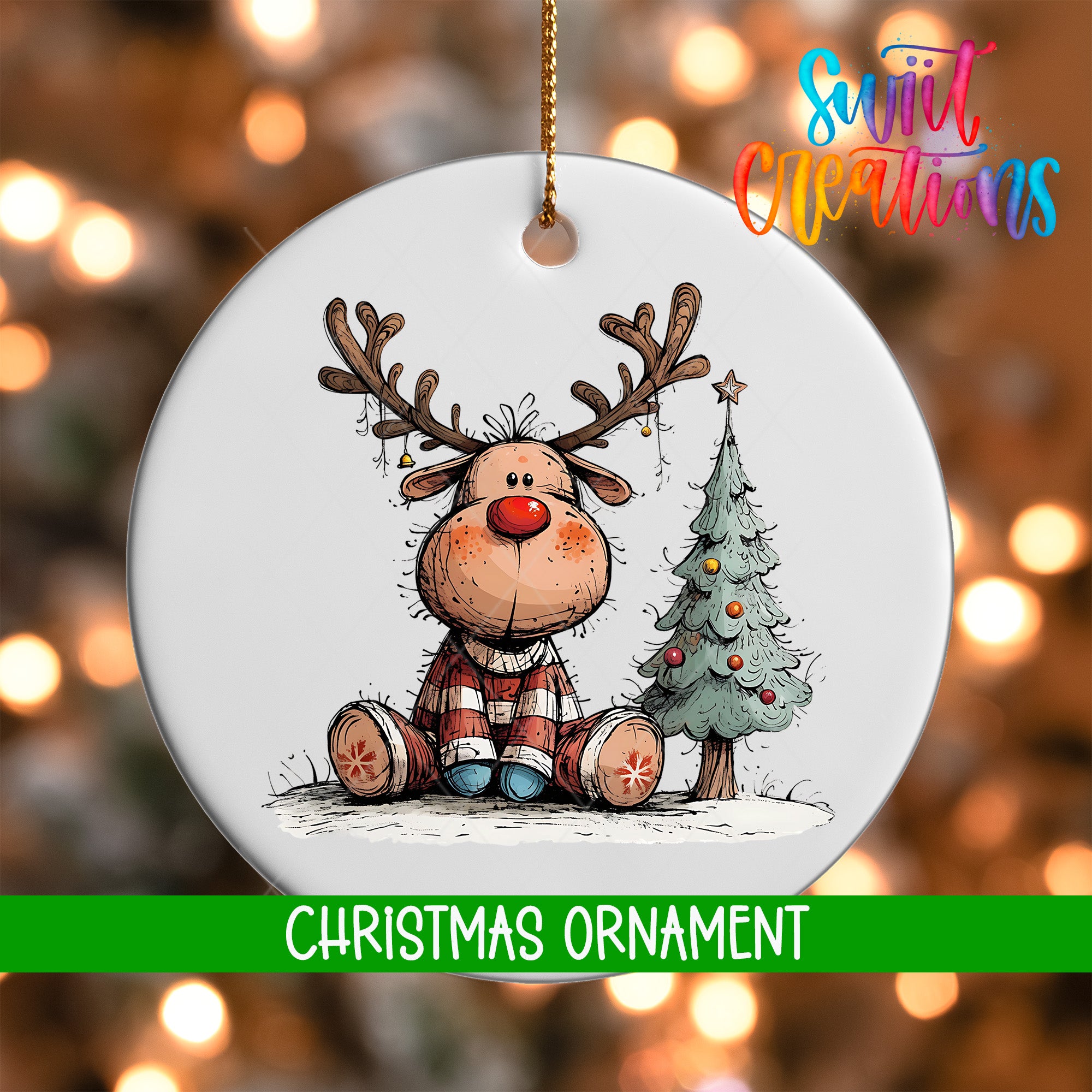 A white Christmas ornament featuring a cartoon reindeer sitting next to a Christmas tree.