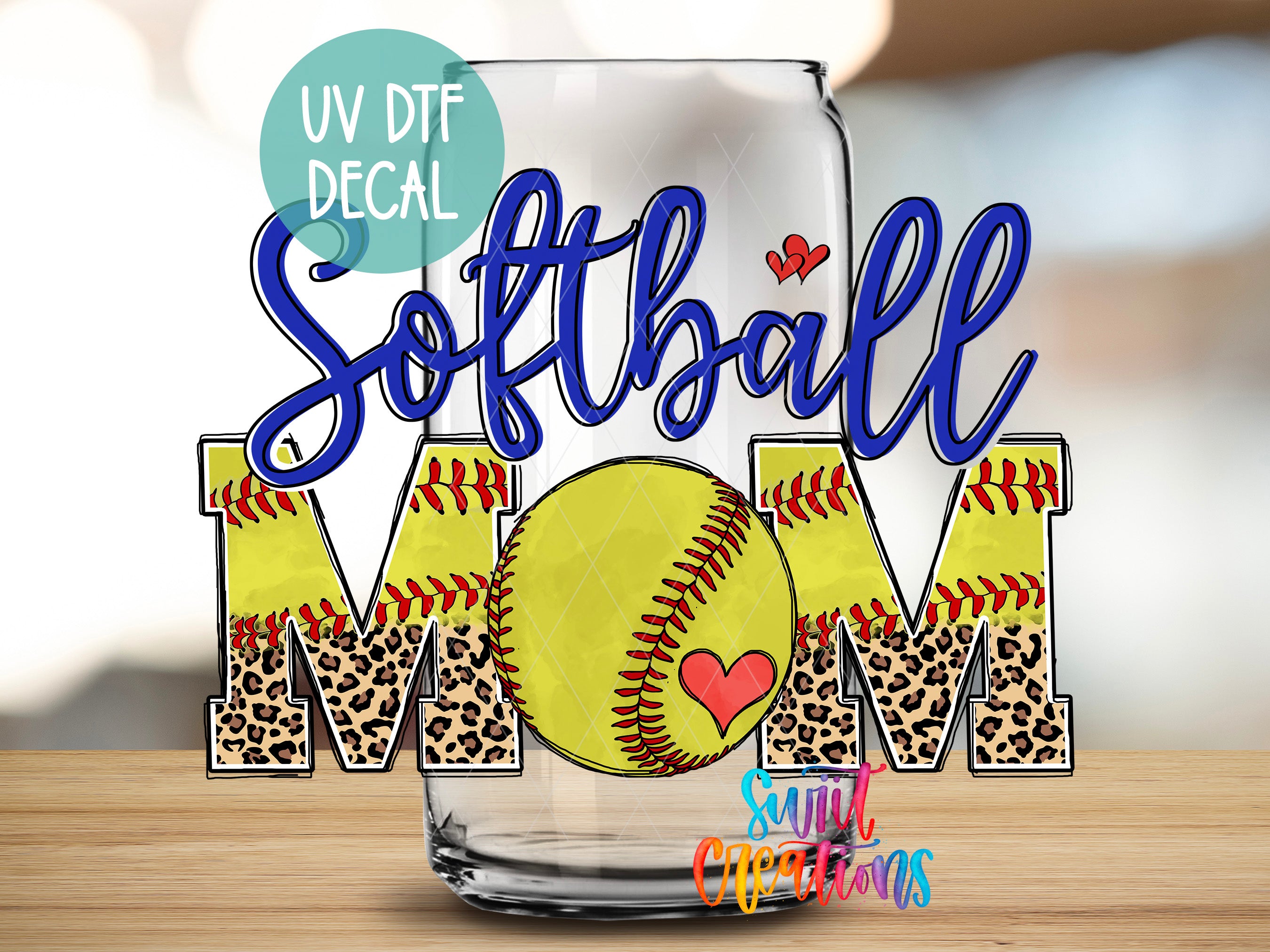 A glass with the word "Softball Mom" written on it, along with a leopard print design and a heart symbol.