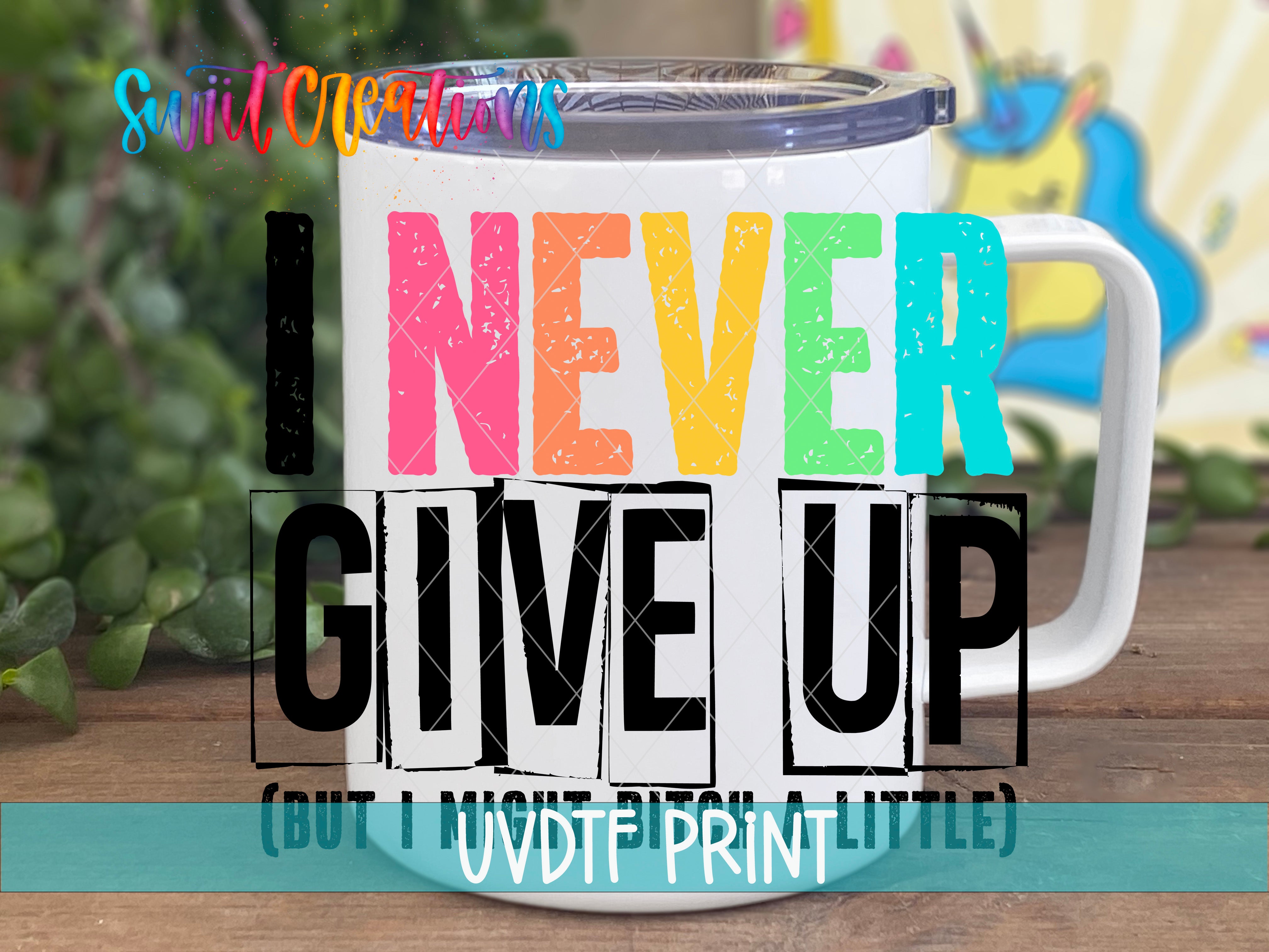 A white mug with colorful text on it, placed on a wooden surface.