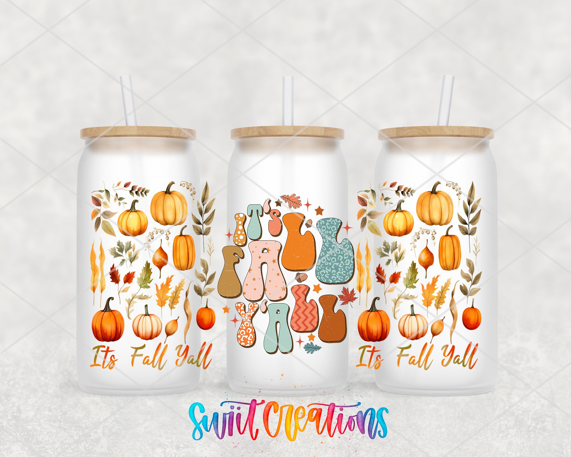 three white glass tumblers with autumn-themed designs and straws.