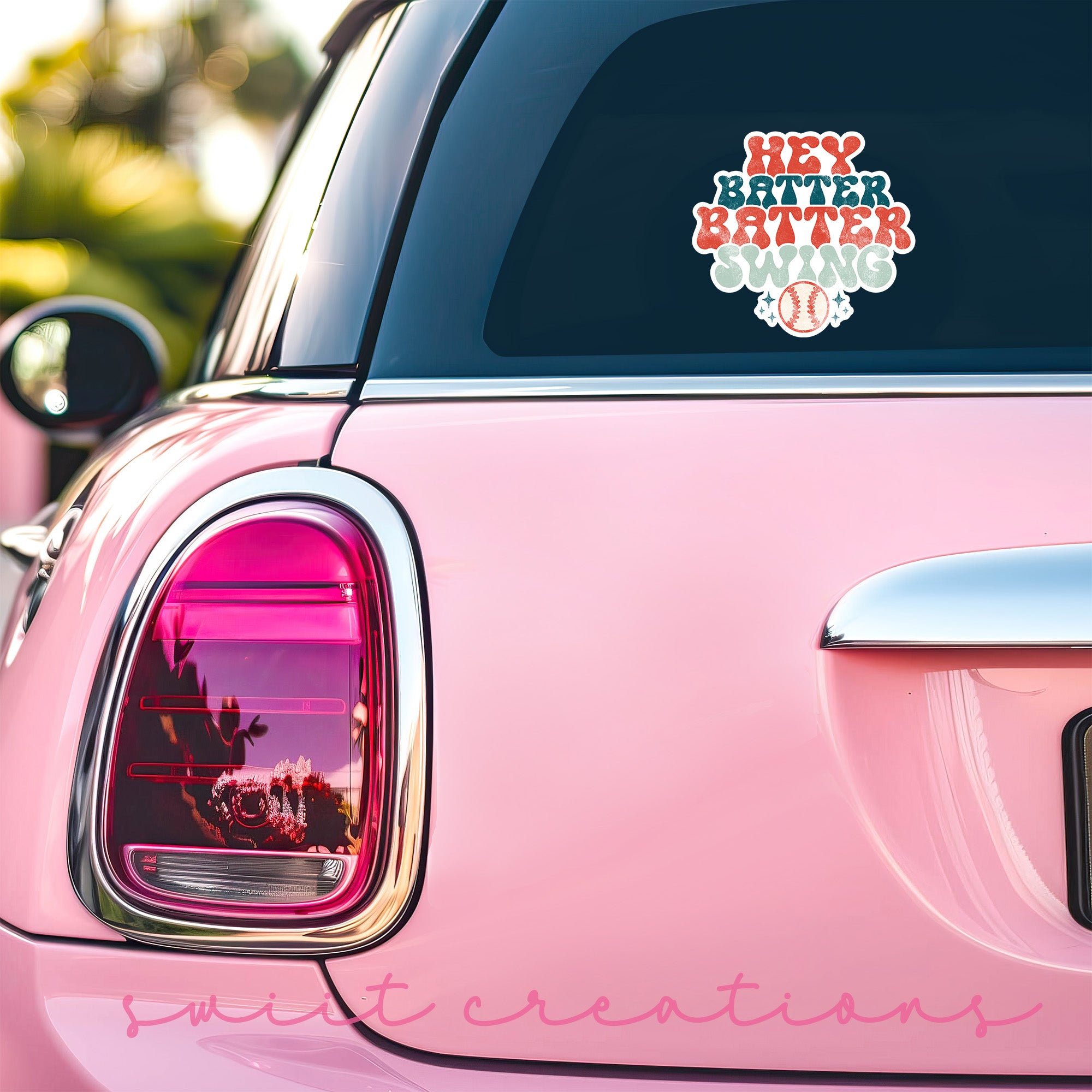 a pink car with a sticker on the back of it