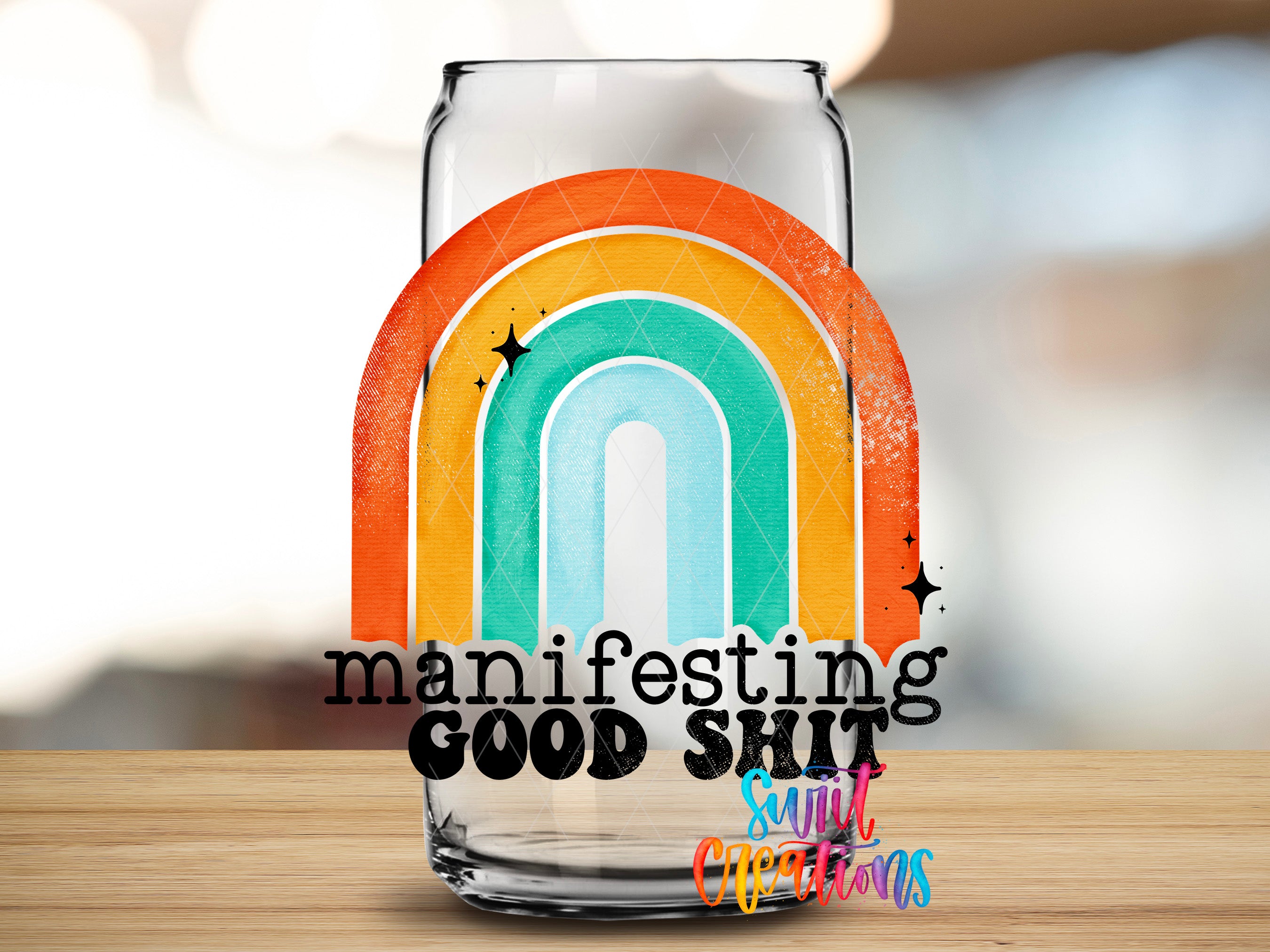 a glass jar with a rainbow design and the text "manifesting good shit" written on it.