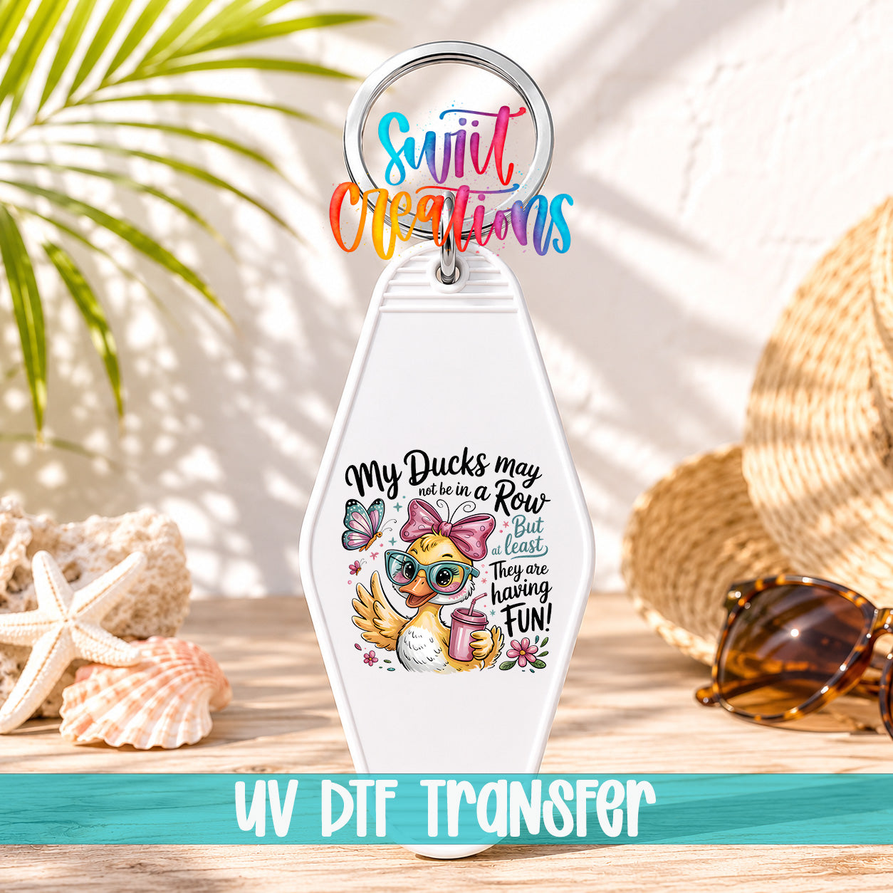 A keychain with a cartoon duck wearing sunglasses and holding a drink, surrounded by sunglasses and a straw hat, with a colorful text overlay that says "My Ducks may be in a Row, but they are the least they are having fun!"
