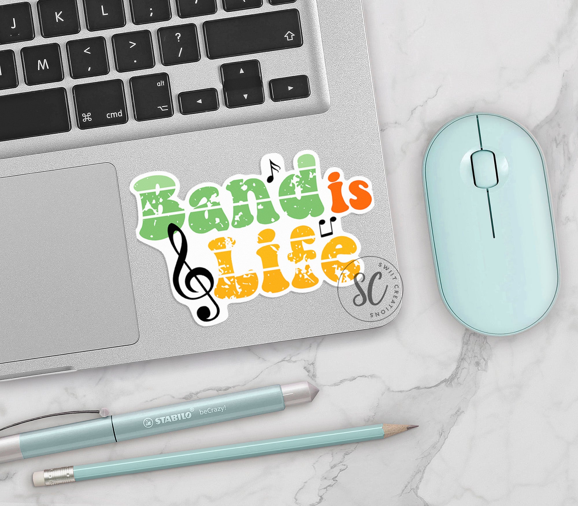 a computer keyboard, mouse, and sticker with the words music is life
