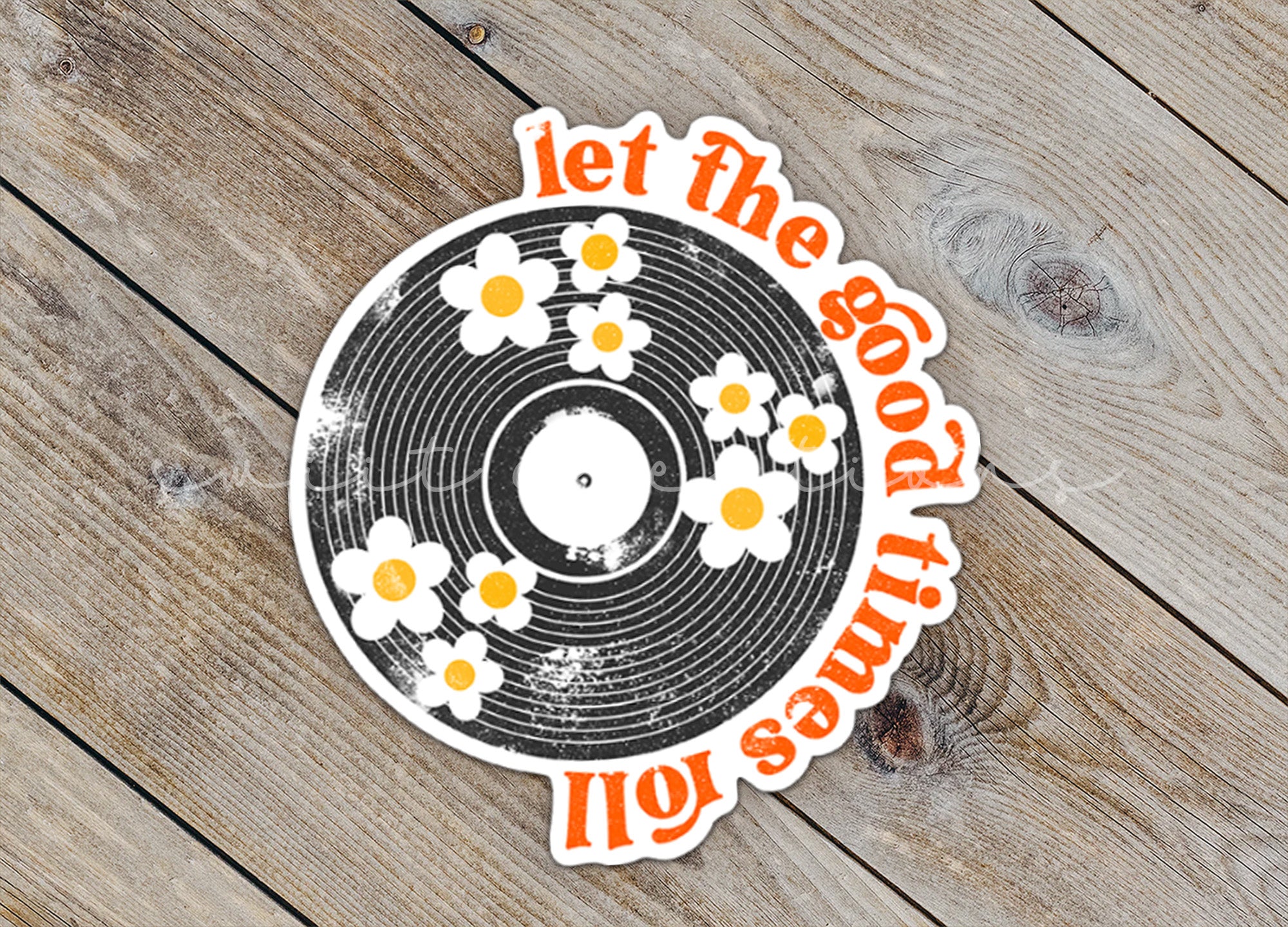 a vinyl record with flowers on it on a wooden surface