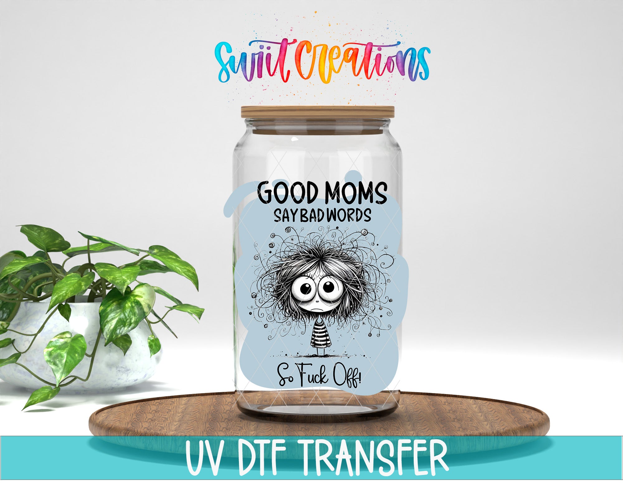 a glass jar with a label that says "GOOD MOMS SAY BAD WORDS So FUCK OFF" and includes a cartoon character. The jar is placed on a wooden surface, and there is a potted plant in the background.