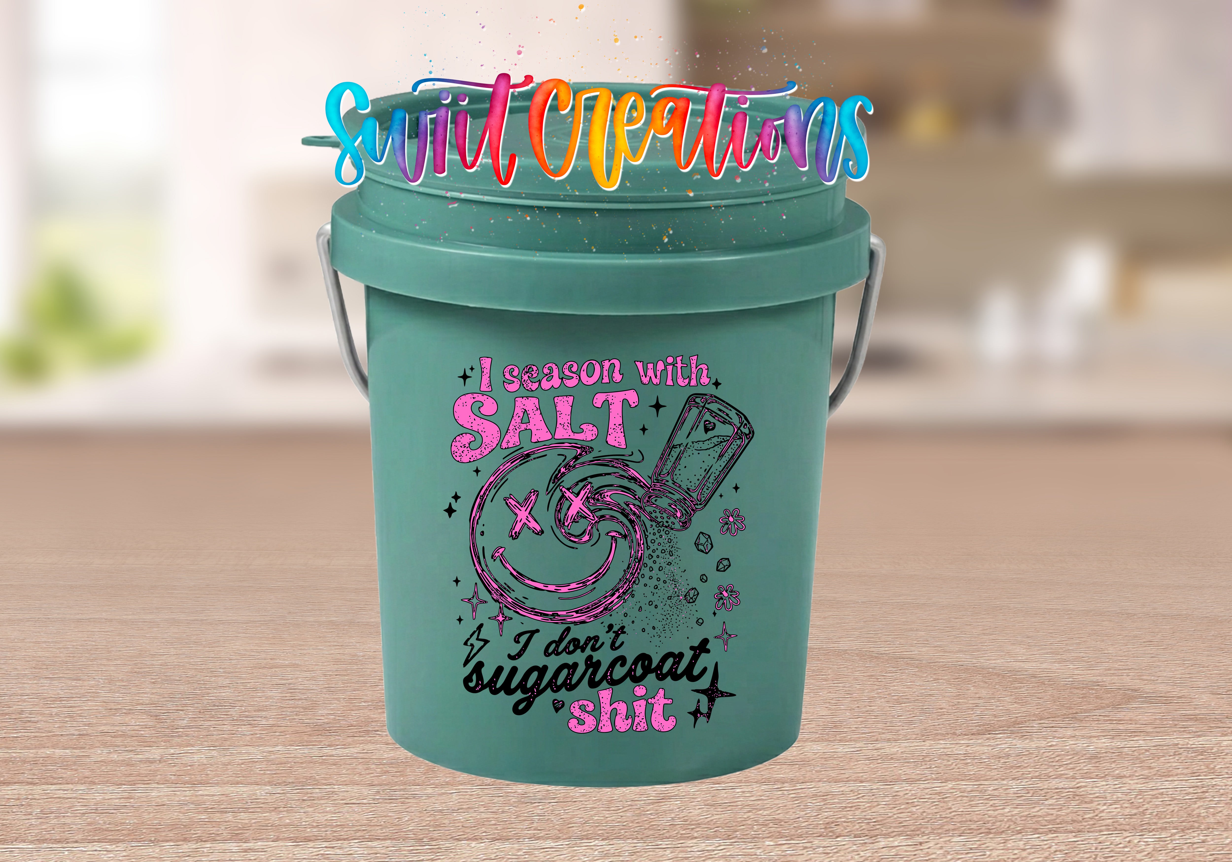 A green bucket with a colorful and whimsical design, featuring text and graphics related to salt and salt-related humor.
