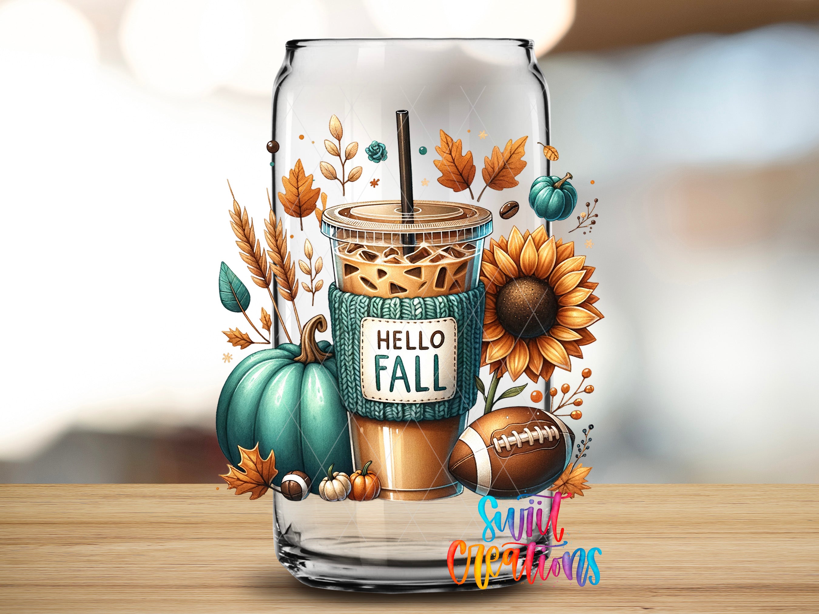 A glass jar filled with a beverage surrounded by autumn-themed decorations, including a pumpkin, sunflower, football, and leaves.