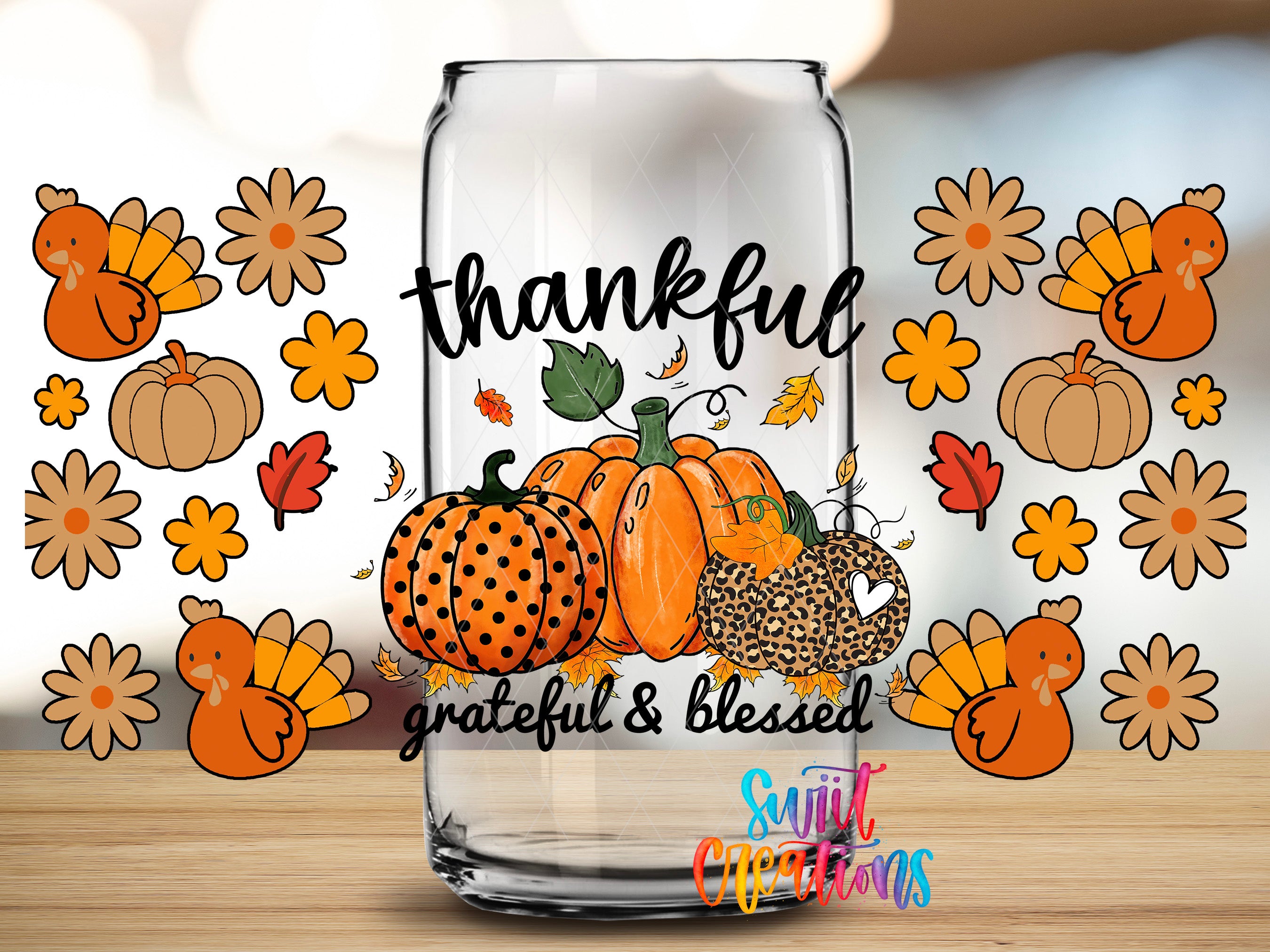 A glass jar with a Thanksgiving-themed design, featuring a pumpkin, leopard print, and a turkey, surrounded by autumn flowers and leaves.