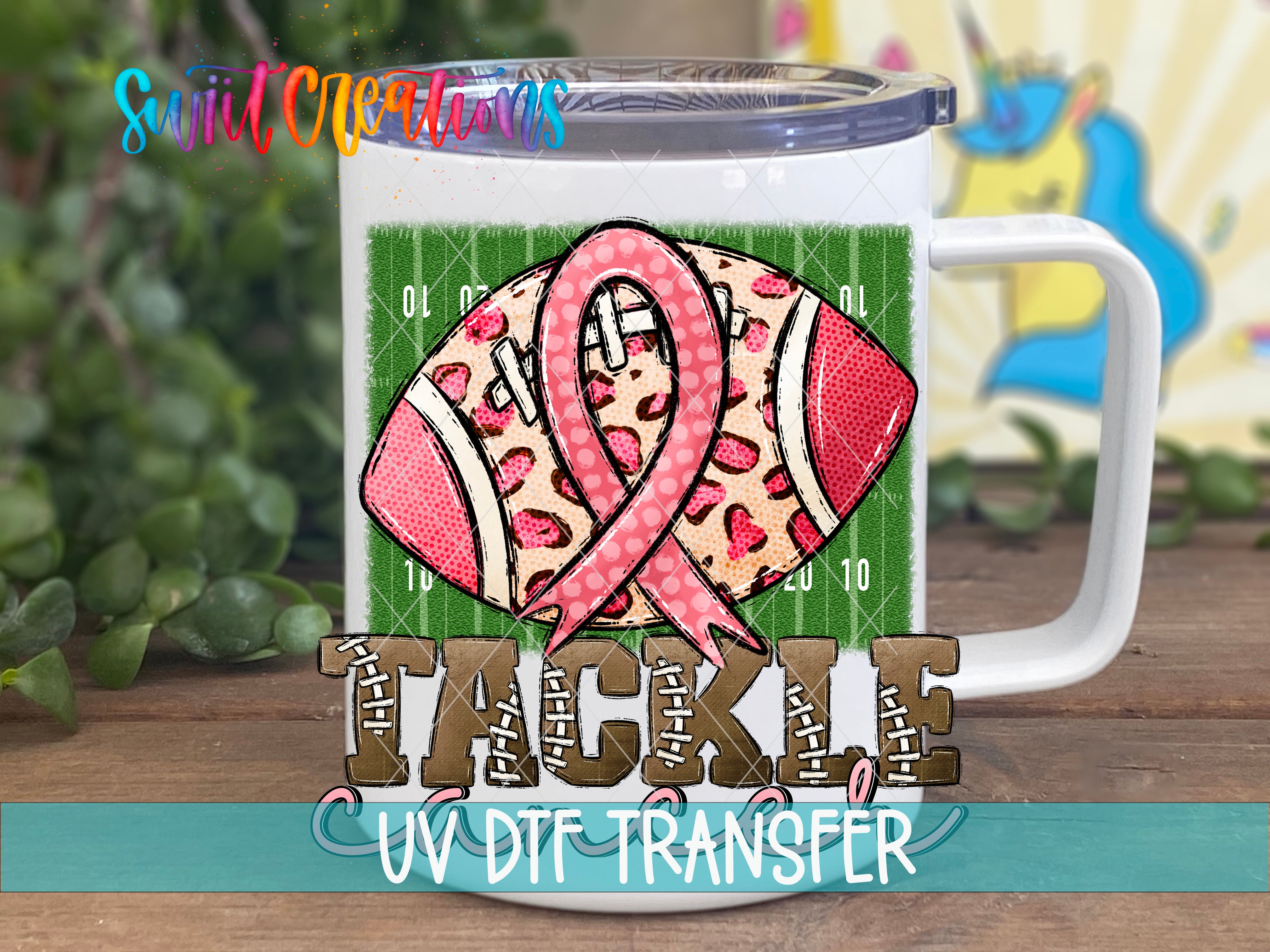 A white mug with a football design and a pink ribbon, representing breast cancer awareness.