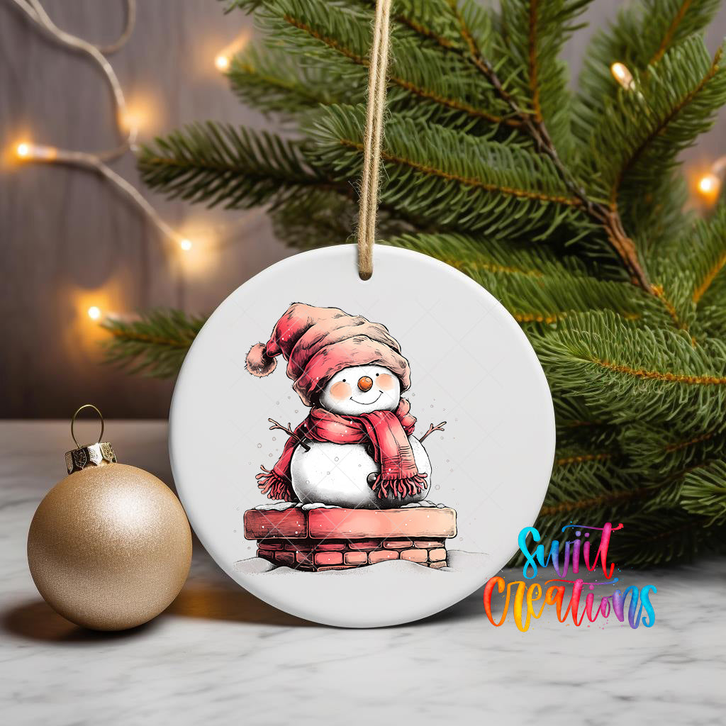 A white ceramic ornament featuring a snowman is displayed on a table, with a Christmas tree and twinkling lights in the background.