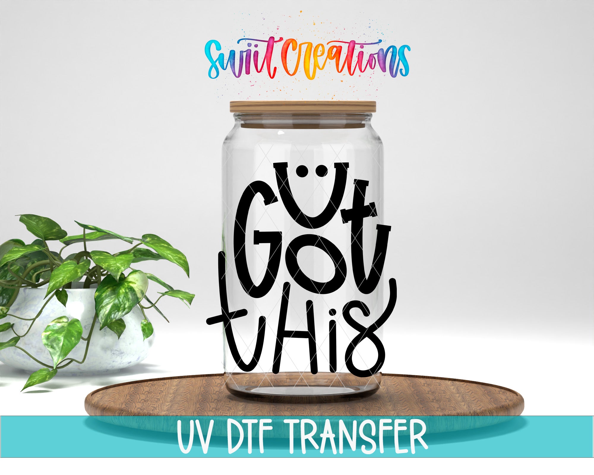 A glass jar with a lid, featuring a hand-drawn text that says "GOT THIS" in a stylized font. The jar is placed on a wooden surface, and there is a potted plant in the background.