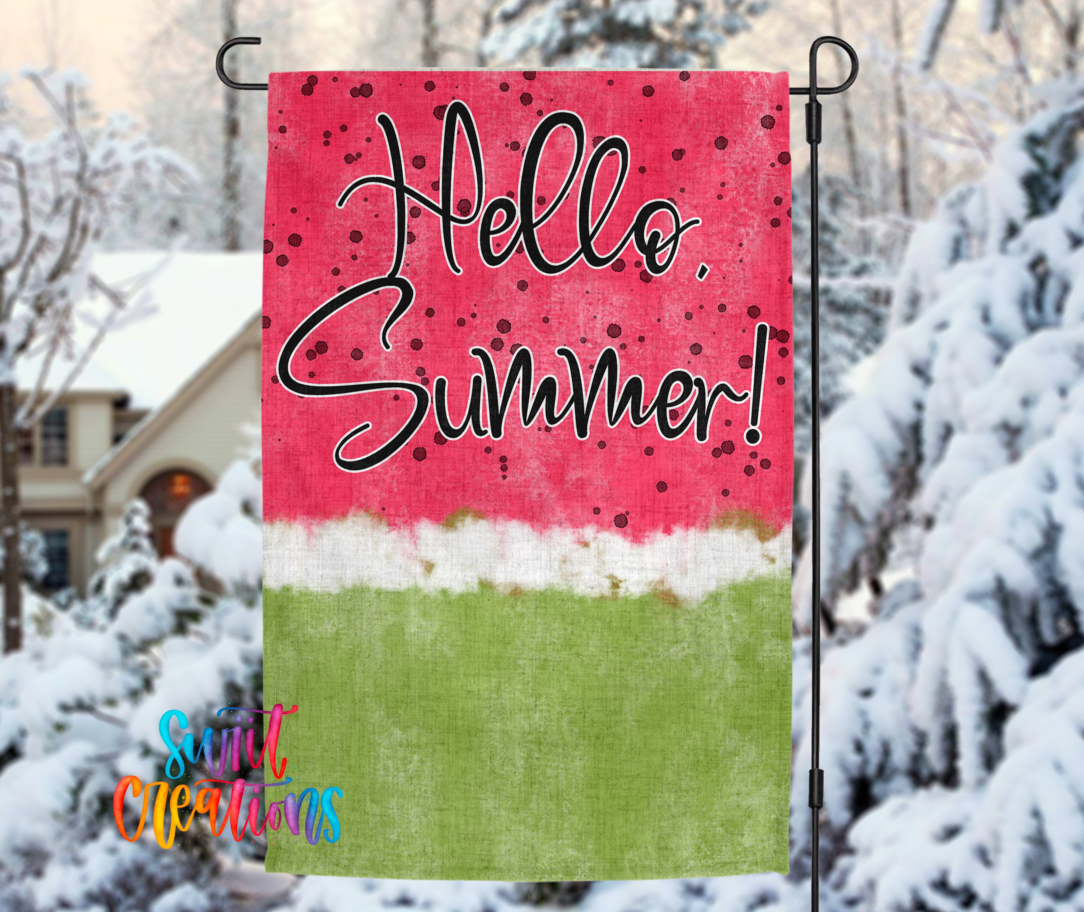 A colorful flag with the text "Hello Summer!" displayed prominently against a red background with a watermelon pattern. The flag is hanging outdoors, with snow-covered trees visible in the background.