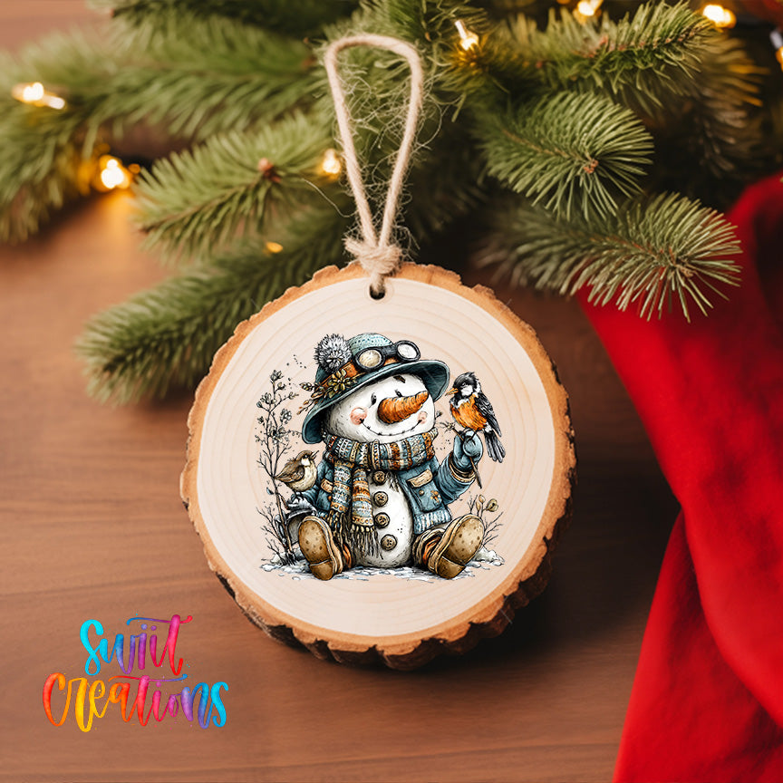 A wooden ornament featuring a snowman holding a bird, with a tree branch and twinkling lights in the background.