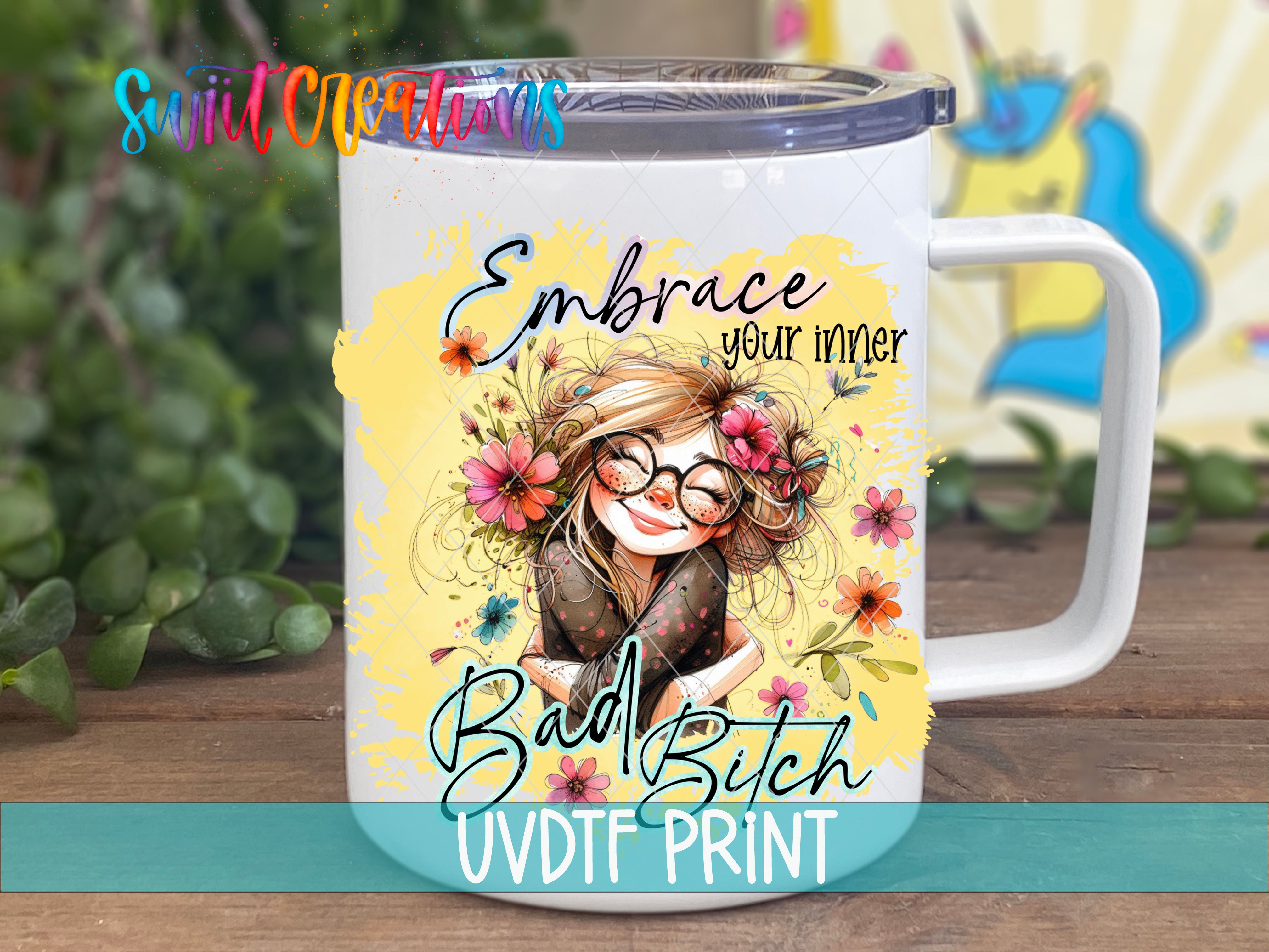 A white mug with a colorful illustration of a woman with flowers and the text "Embrace your inner Bad Bitch UVDF PRINT" printed on it.