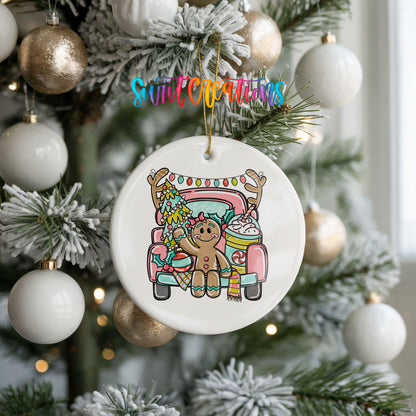 A Christmas tree decorated with ornaments, including a white ornament with a gingerbread man design hanging from a tree branch.