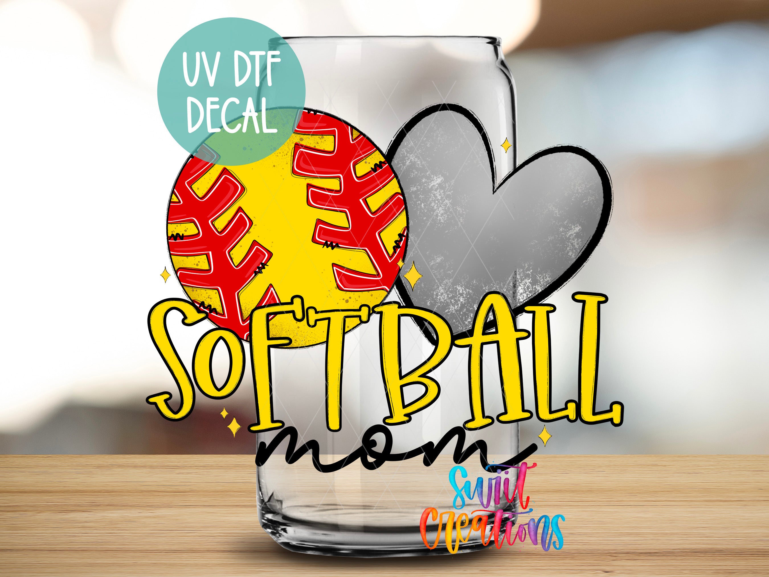 a glass with a softball and a heart cutout, along with the text "Softball mom" and "Sunlit Creations" written on it.