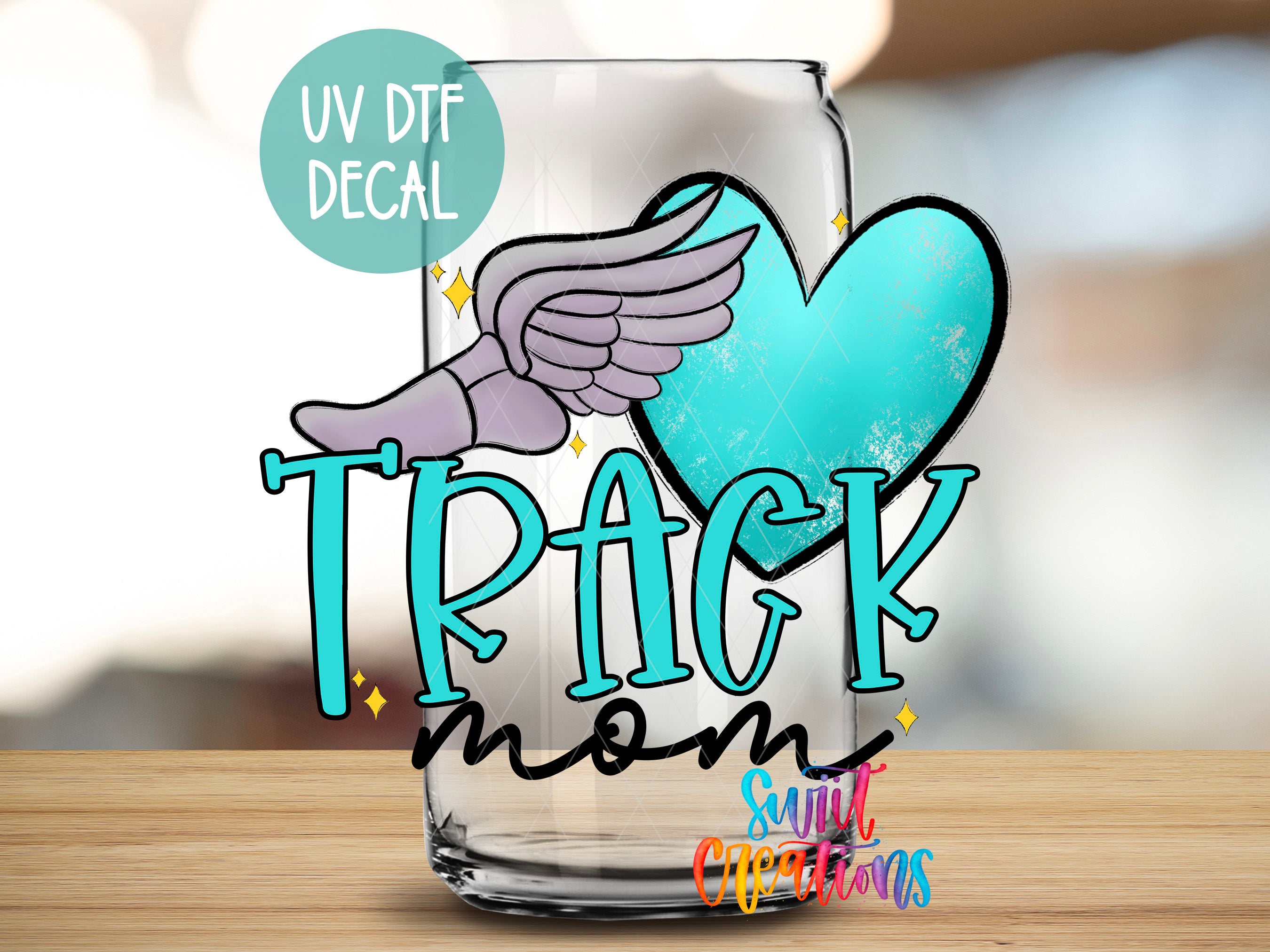 A glass with a UV decal that says "TRACK mom" and a heart-shaped decal with a winged figure.