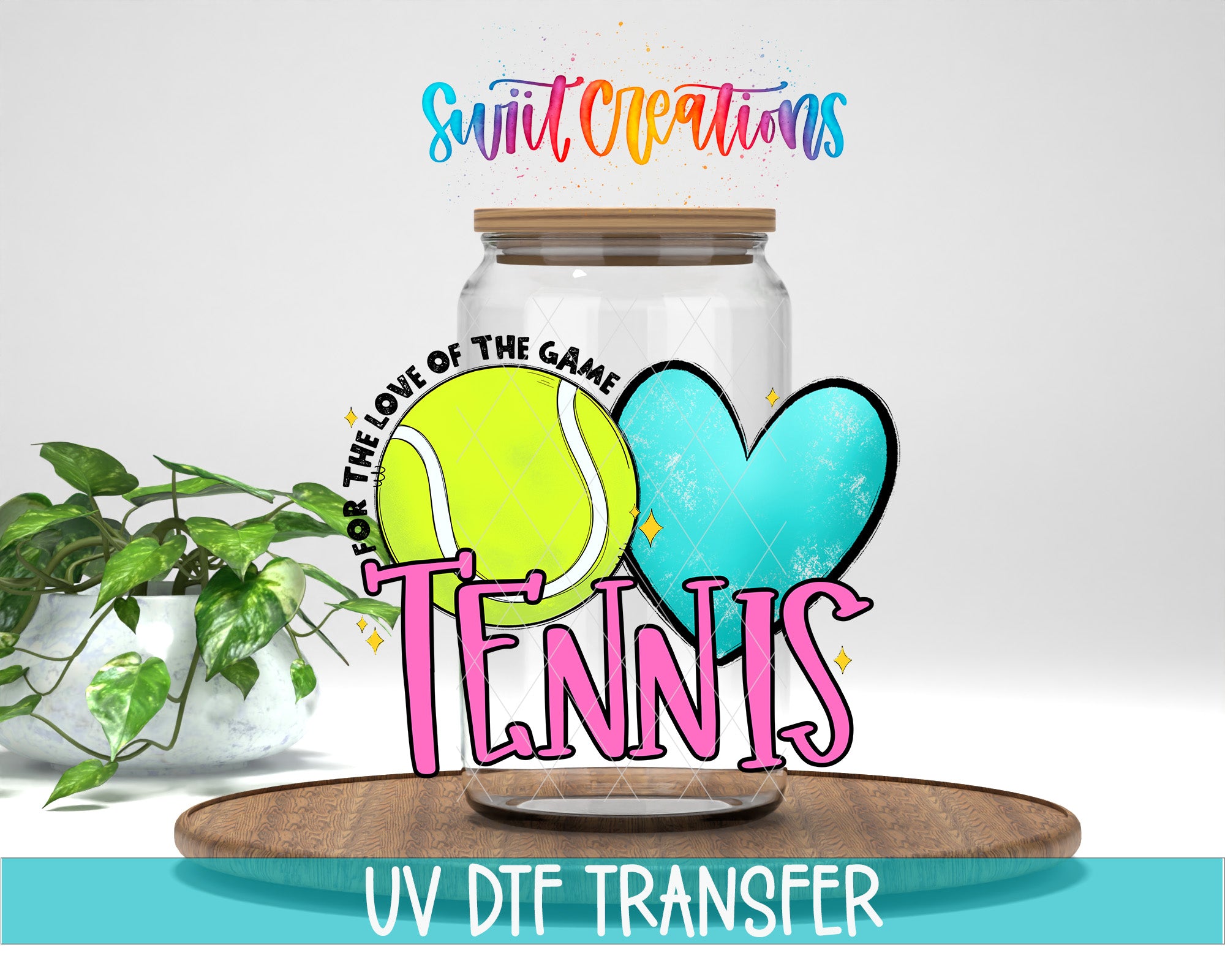 A glass jar with a tennis ball inside, surrounded by a heart and the word "Tennis" in pink and yellow text. The jar is placed on a wooden surface, and there is a plant in the background.