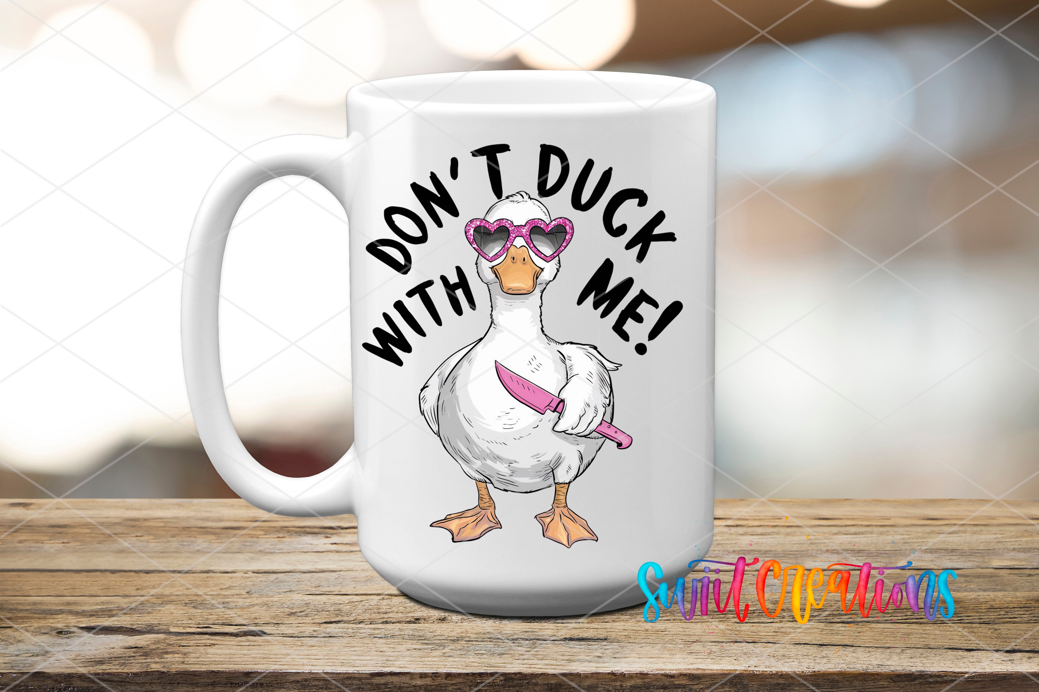 A white ceramic mug with a cartoon duck wearing sunglasses and holding a knife, with the text "DON'T DUCK WITH ME!" printed on it.