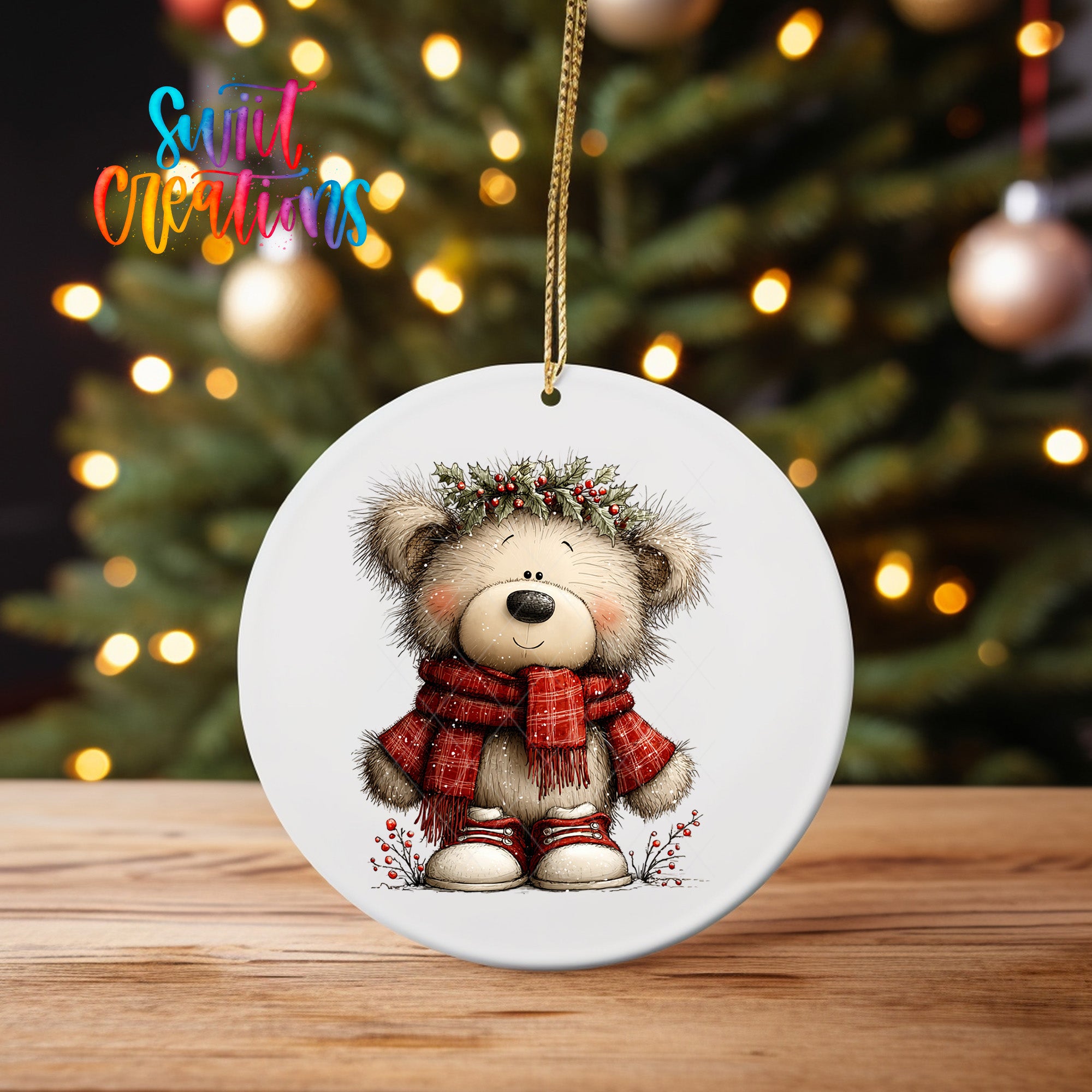 A white ceramic ornament featuring a teddy bear wearing a red scarf and a wreath on its head, set against a blurred background of Christmas lights.