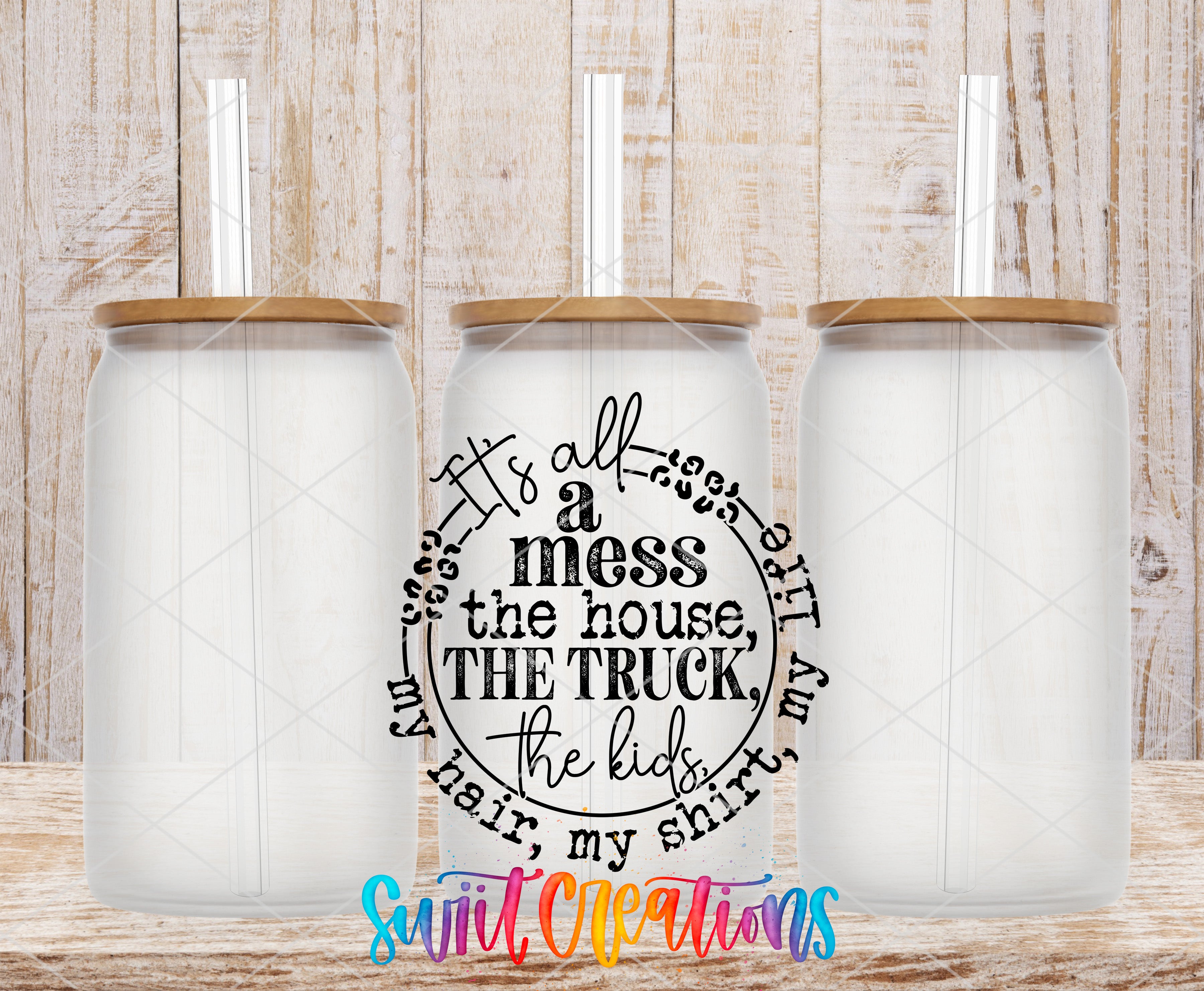 three clear glass jars with wooden lids, arranged in a row against a wooden background. The jars have straws sticking out of the tops. The image also contains text that reads "It's all a mess the house the truck the kids my hair my shirt" and "Sweet Creations" written in a colorful, stylized font.