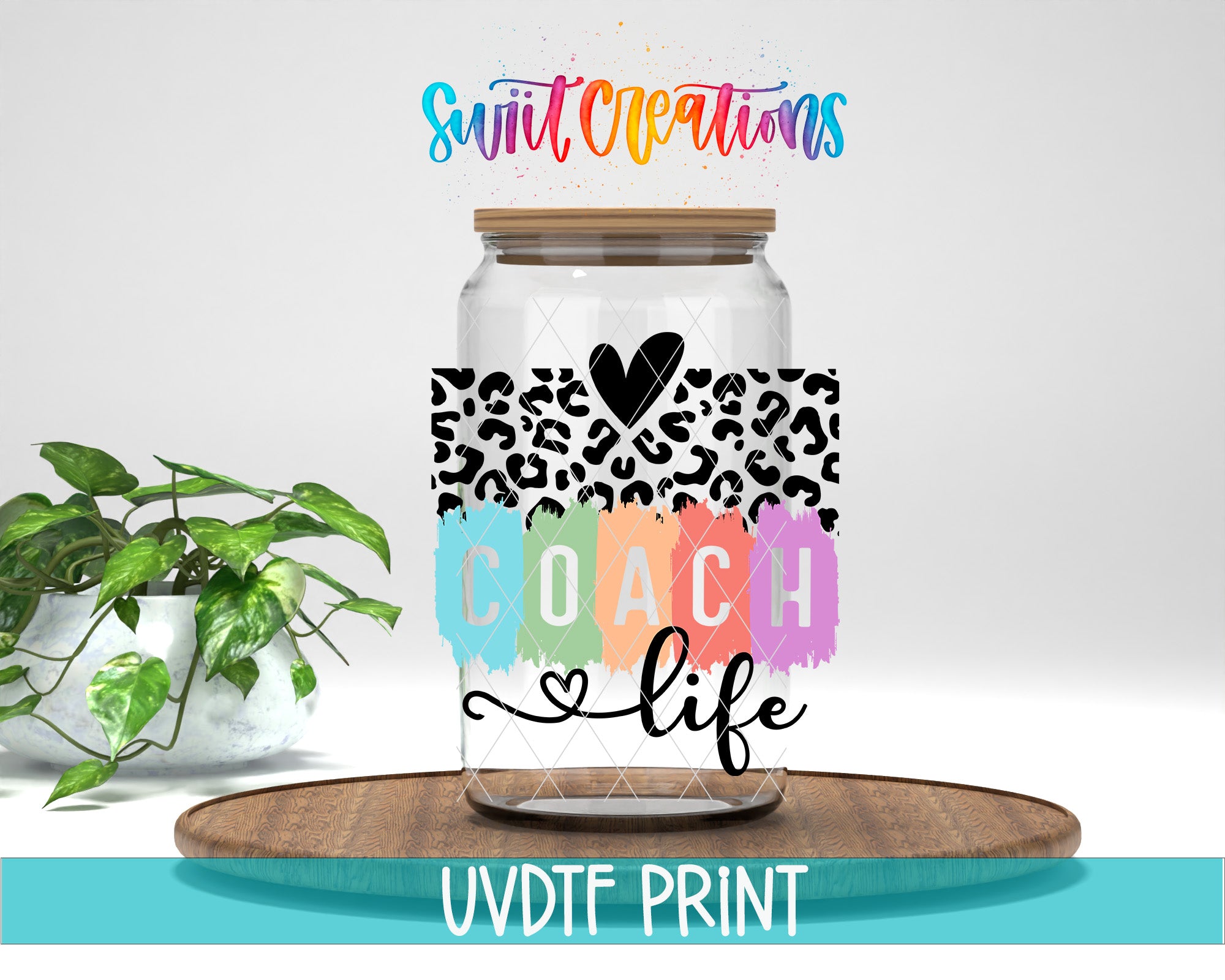 a glass jar with a leopard print design and the word "COACH" written on it, placed on a wooden surface. There is also a potted plant in the background.