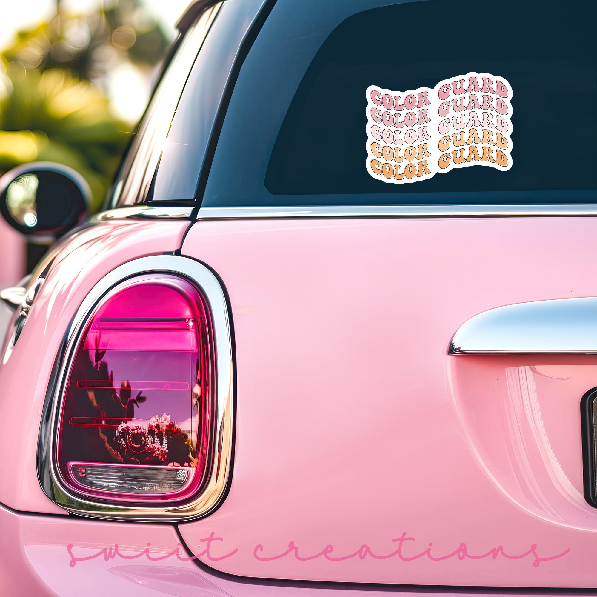 a pink car with stickers on the back of it