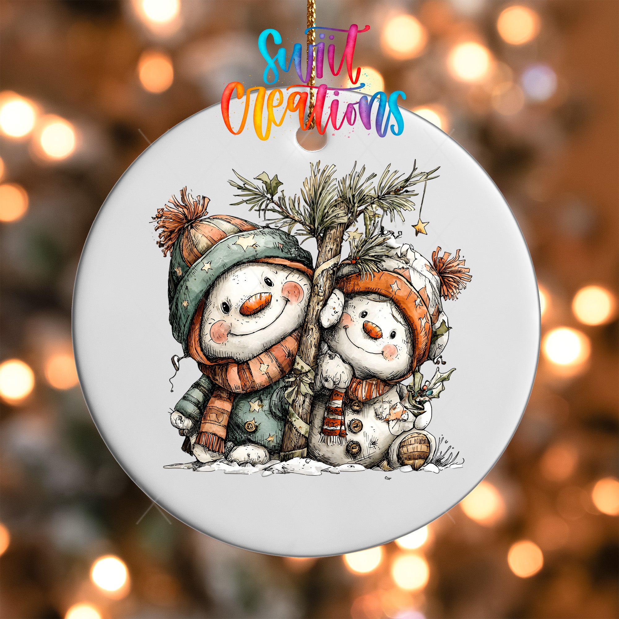 A white ornament featuring two snowmen, one wearing a green hat and the other wearing an orange hat, sitting next to a tree.