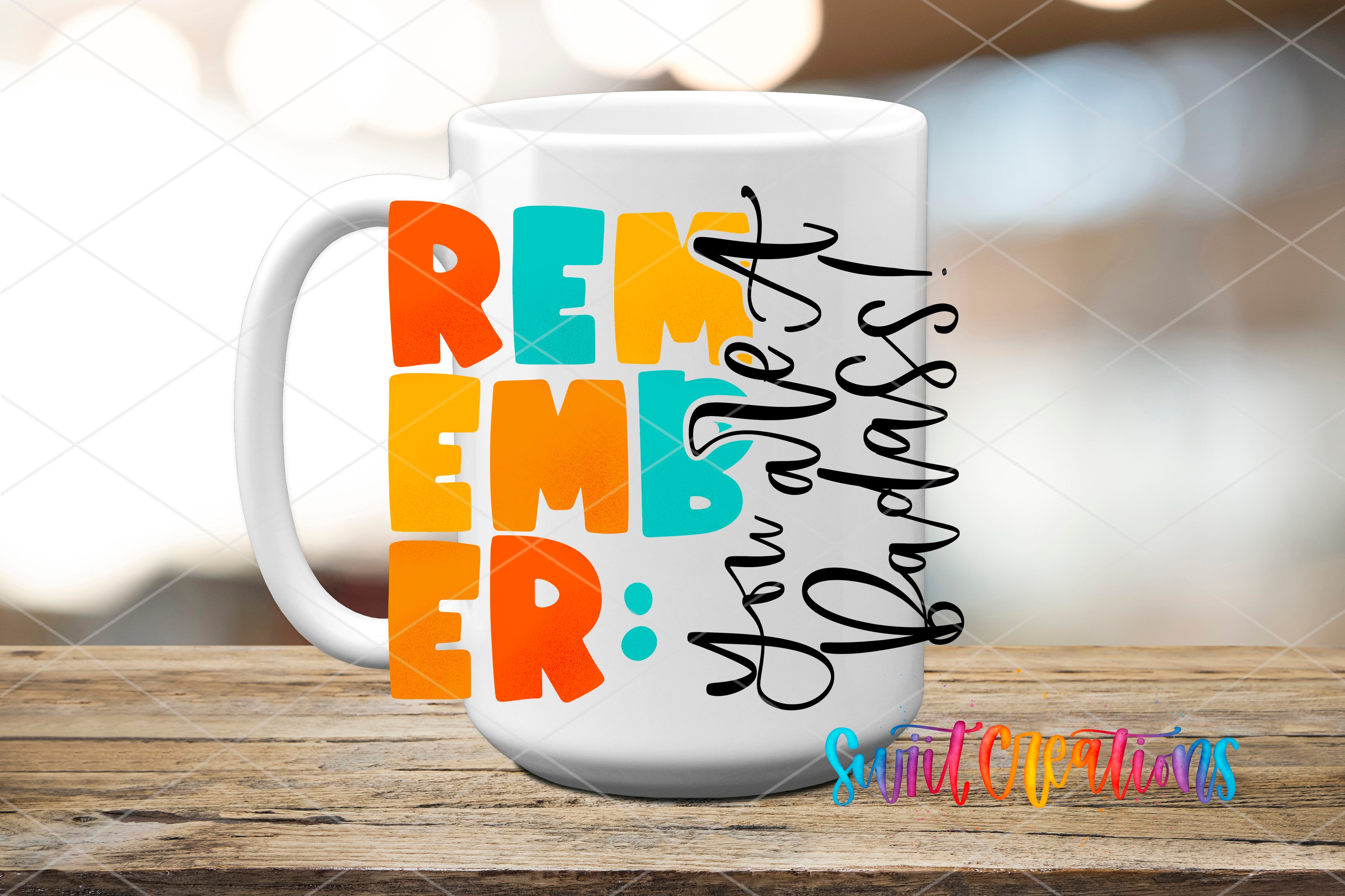 A white mug with colorful text on it, placed on a wooden surface.