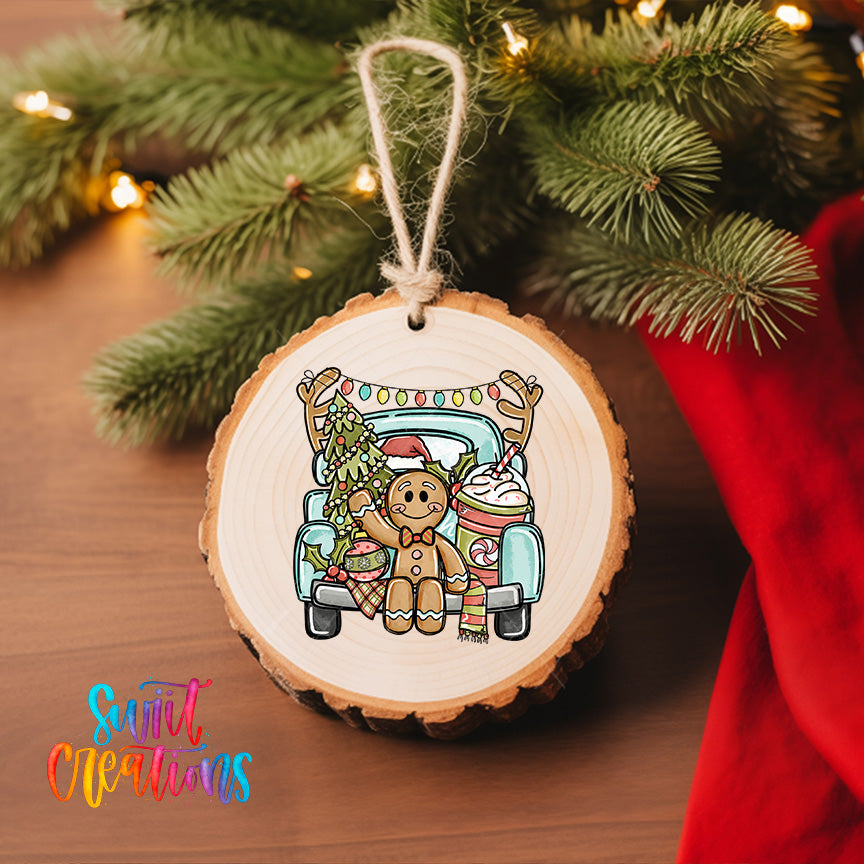 A wooden ornament featuring a gingerbread man sitting in a truck, surrounded by Christmas decorations, is hanging on a Christmas tree.