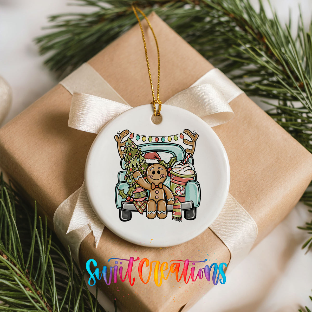 A white ceramic ornament with a gingerbread man and reindeer on a truck, surrounded by pine branches and a ribbon.