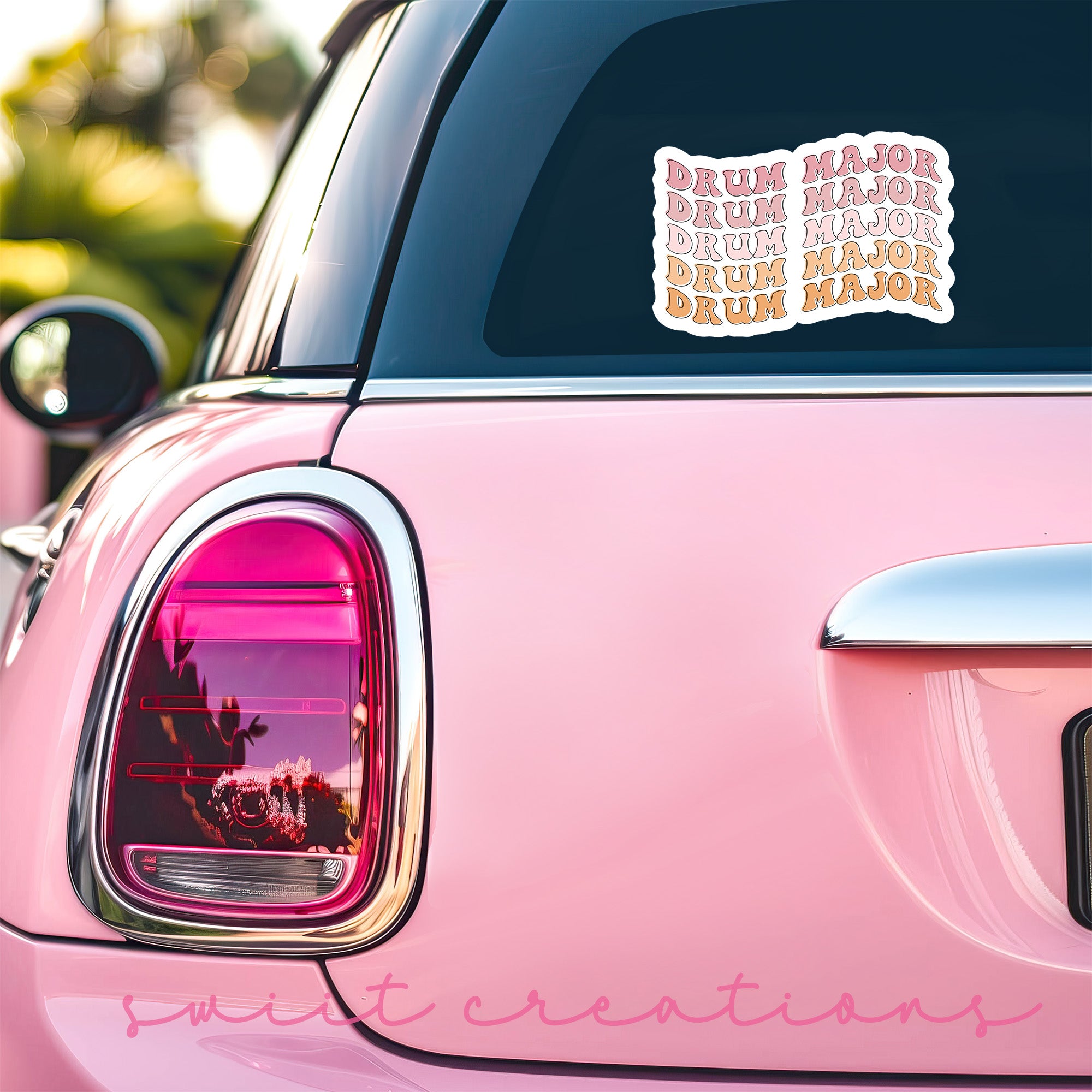 a pink car with a sticker on the back of it