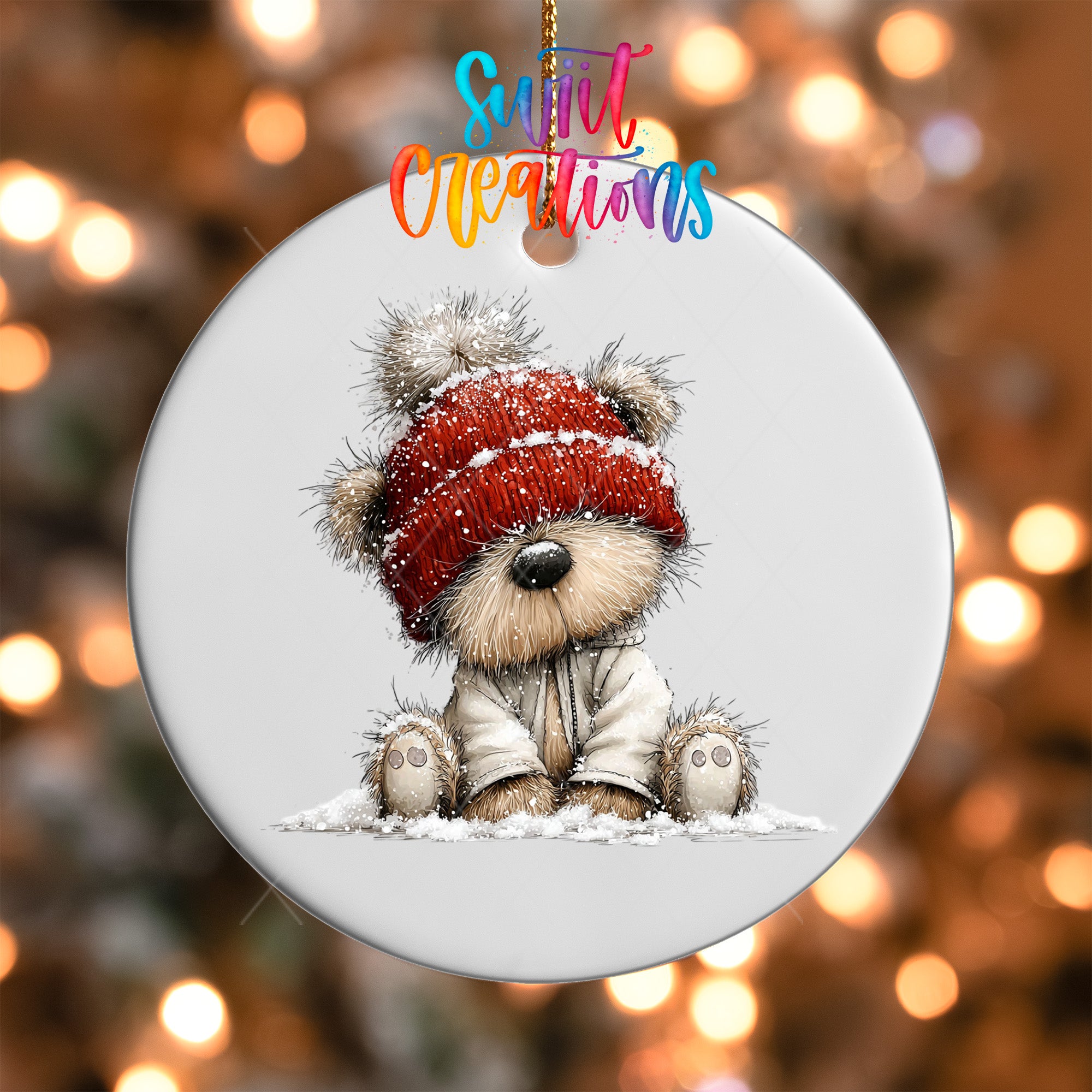 A white ornament with a teddy bear wearing a red hat and sitting in the snow.
