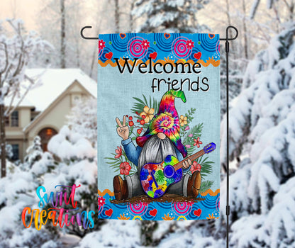 A colorful welcome sign featuring a gnome holding a peace sign, surrounded by flowers and snow, with a house in the background.