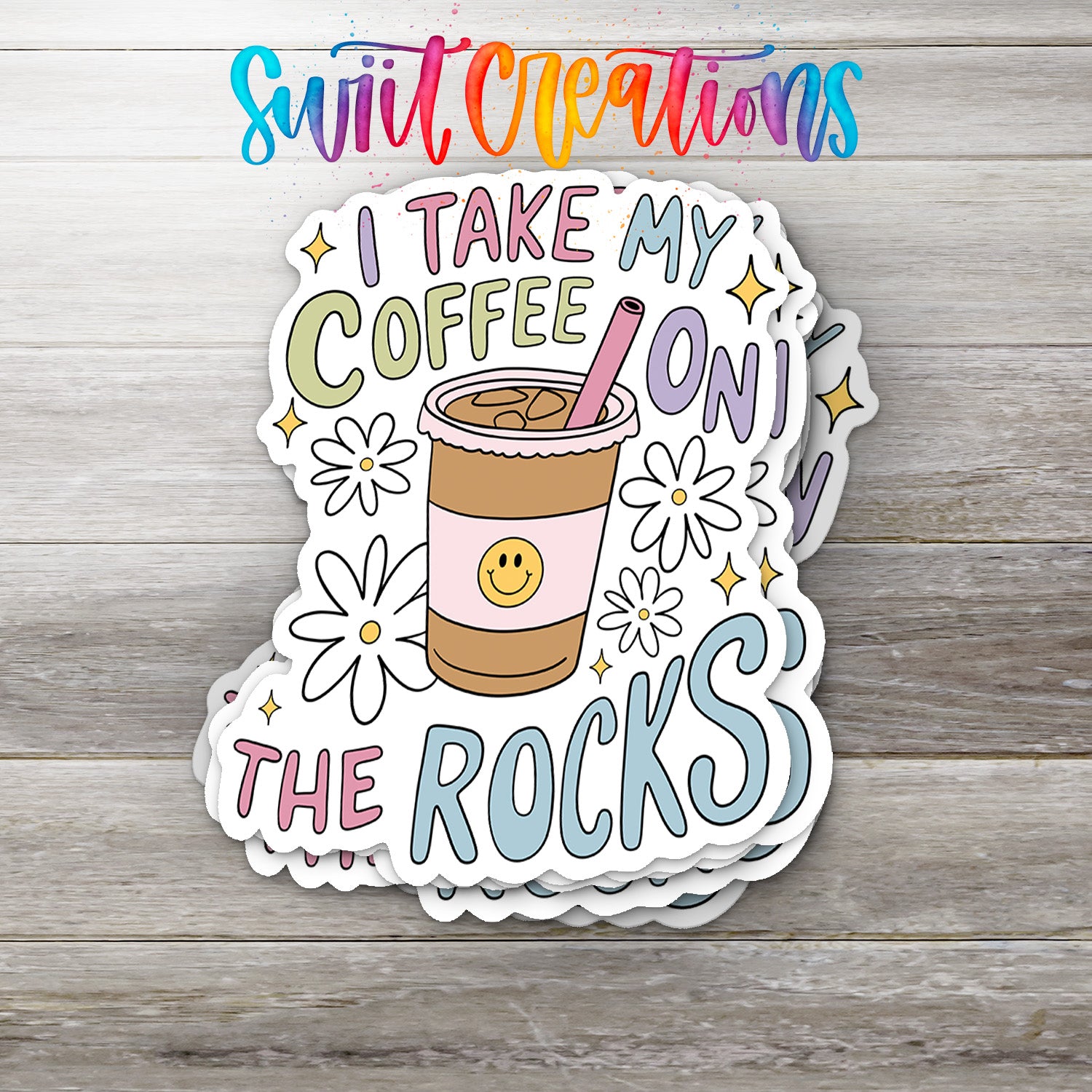 A sticker with a coffee cup and flowers, along with the text "I TAKE MY COFFEE ON THE ROCKS" written on it.