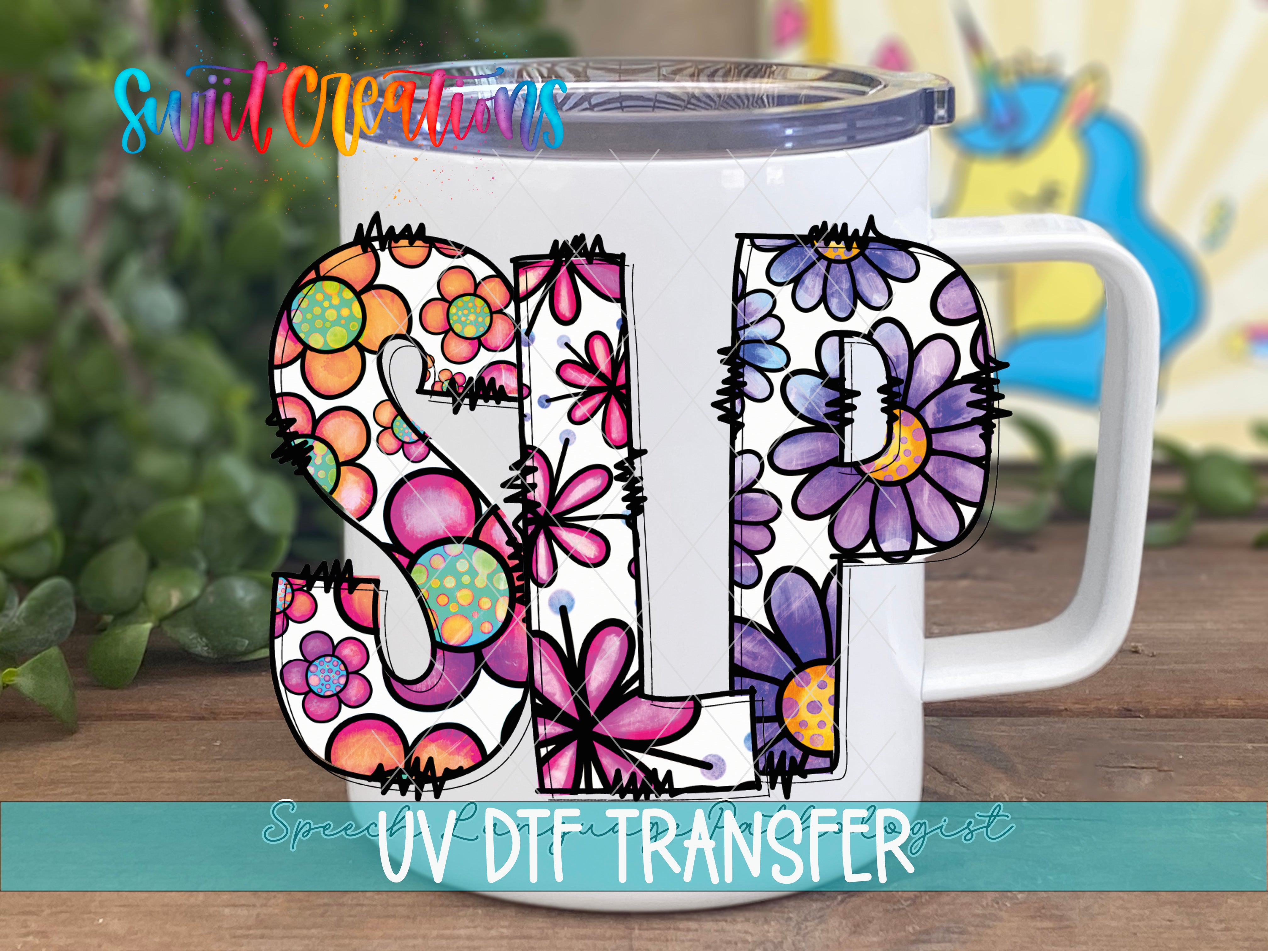 A white mug with colorful floral designs and the letters "SLP" printed on it.