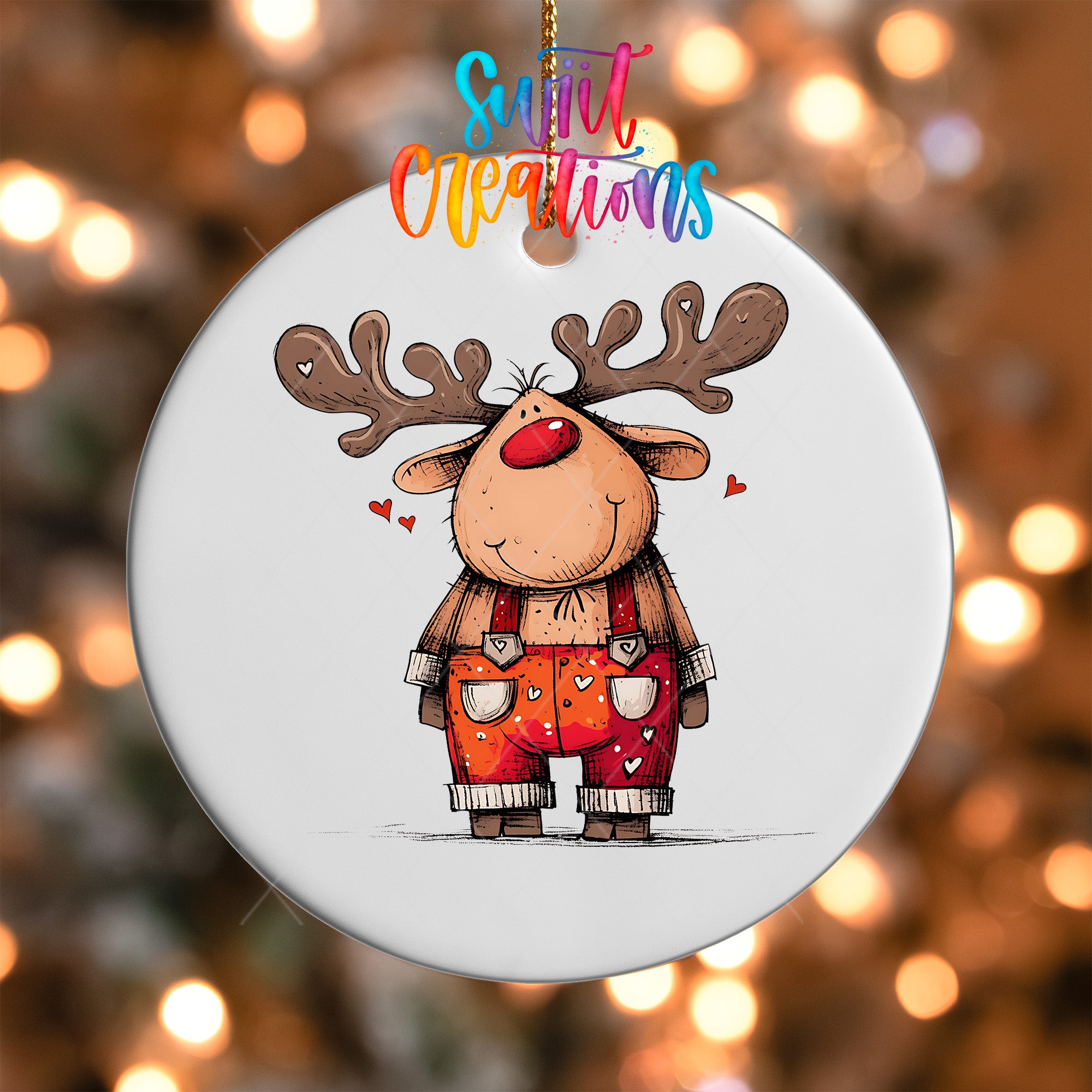 A white ornament featuring a cartoon reindeer with antlers and a red nose, wearing orange overalls with hearts on them.