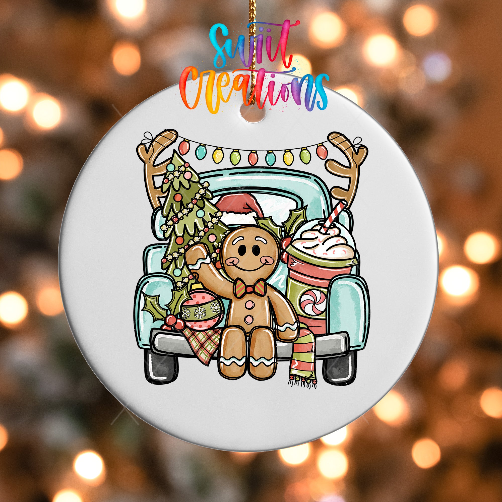 A white ornament with a gingerbread man and Christmas decorations, including a decorated Christmas tree, hanging from a string.