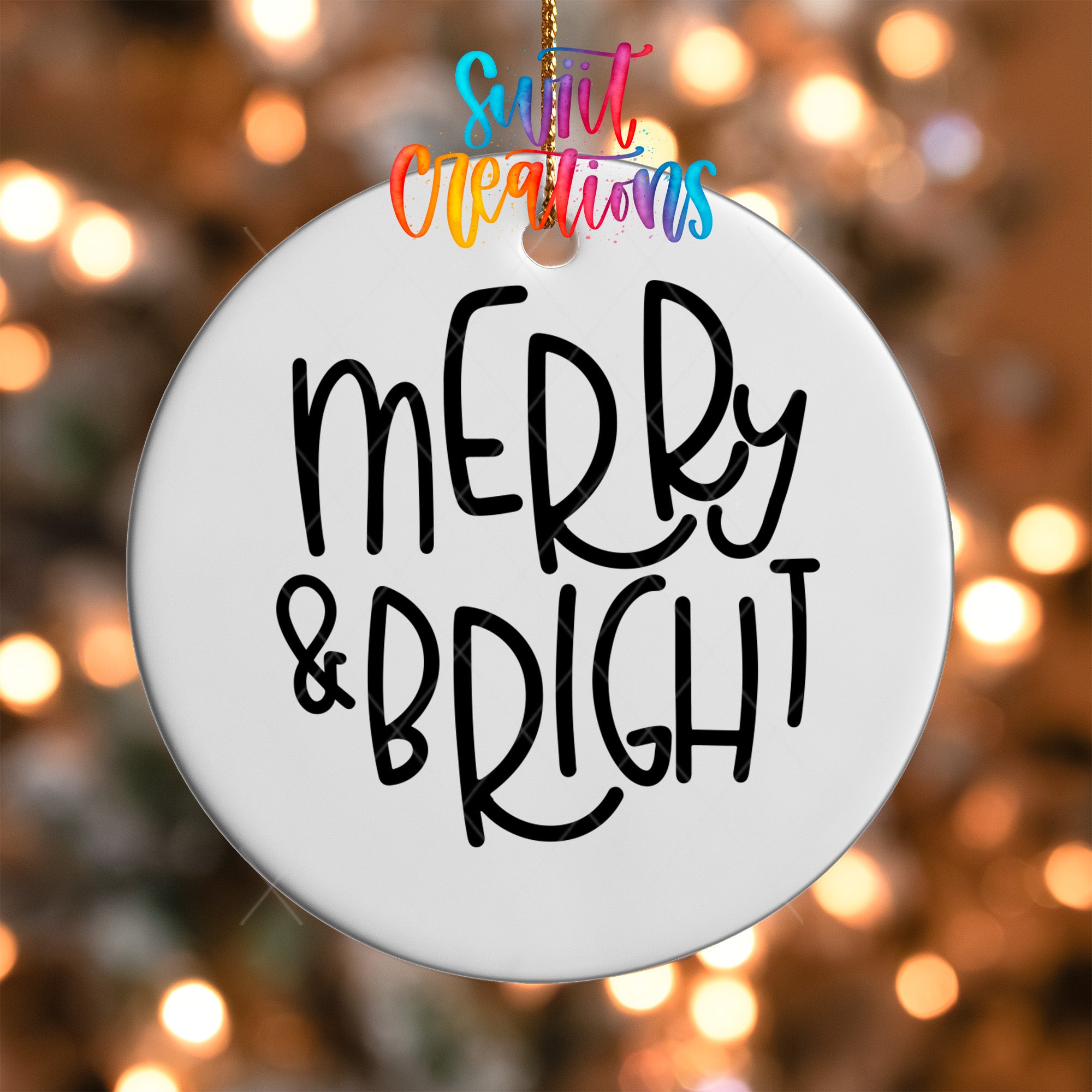 A white ornament with the text "MERRY & BRIGHT" written on it, hanging against a background of colorful lights.