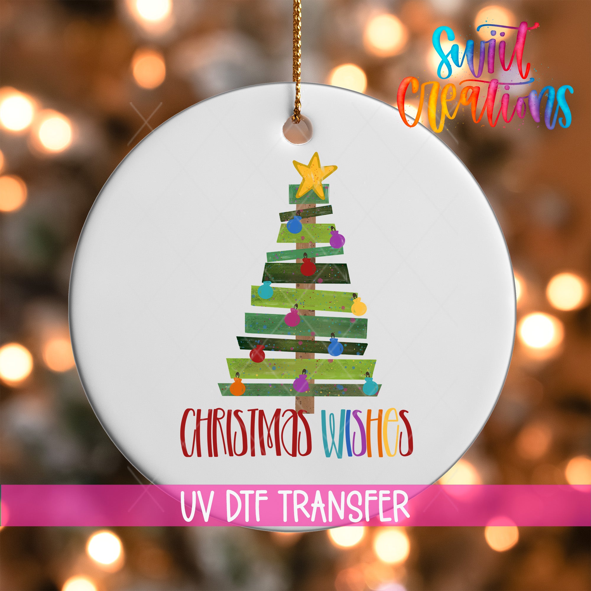 A white Christmas tree ornament with colorful ornaments and a star on top, hanging against a background of colorful lights.