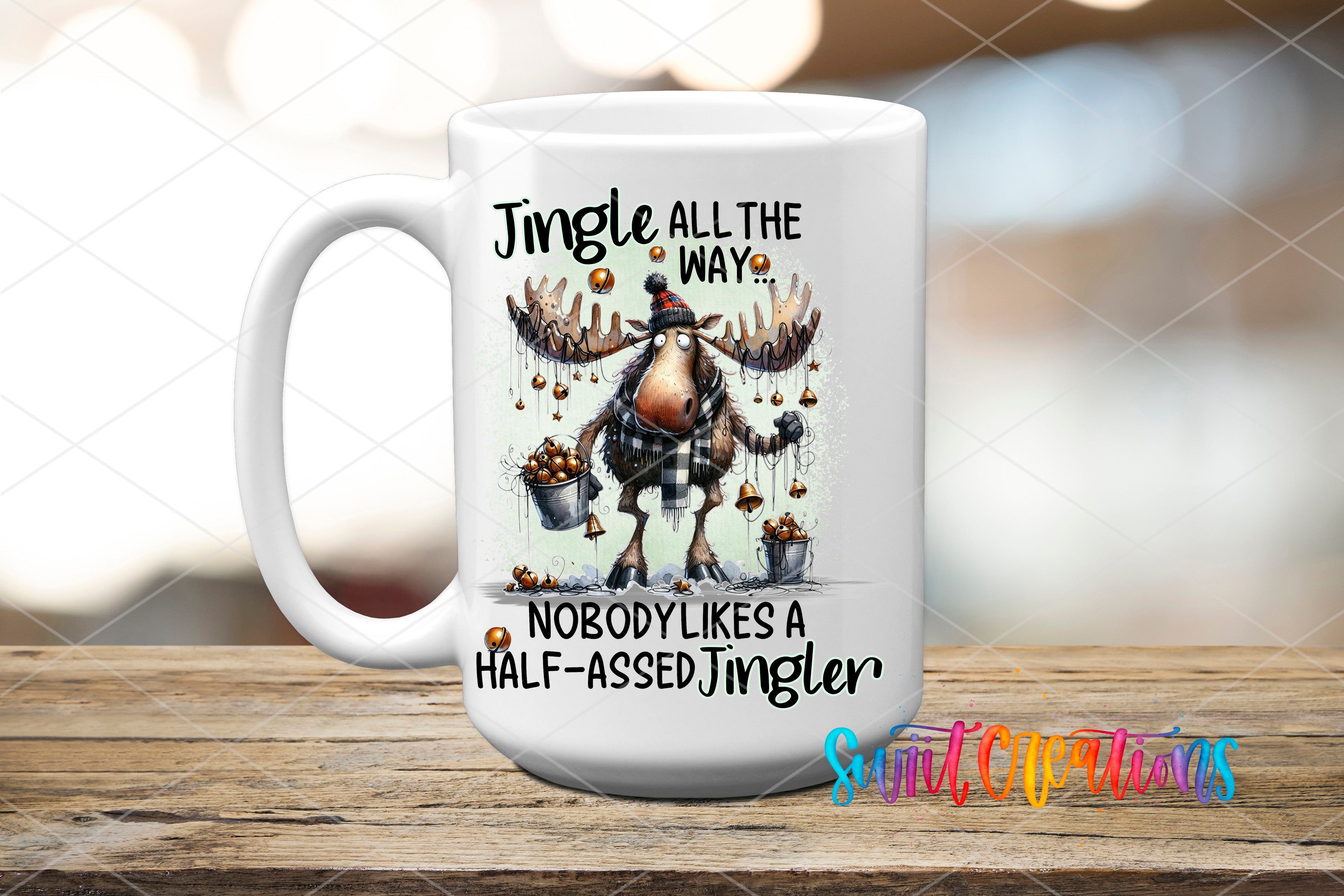 A white ceramic mug with a jingle all the way mug design featuring a cartoon moose holding a bucket of Christmas lights.