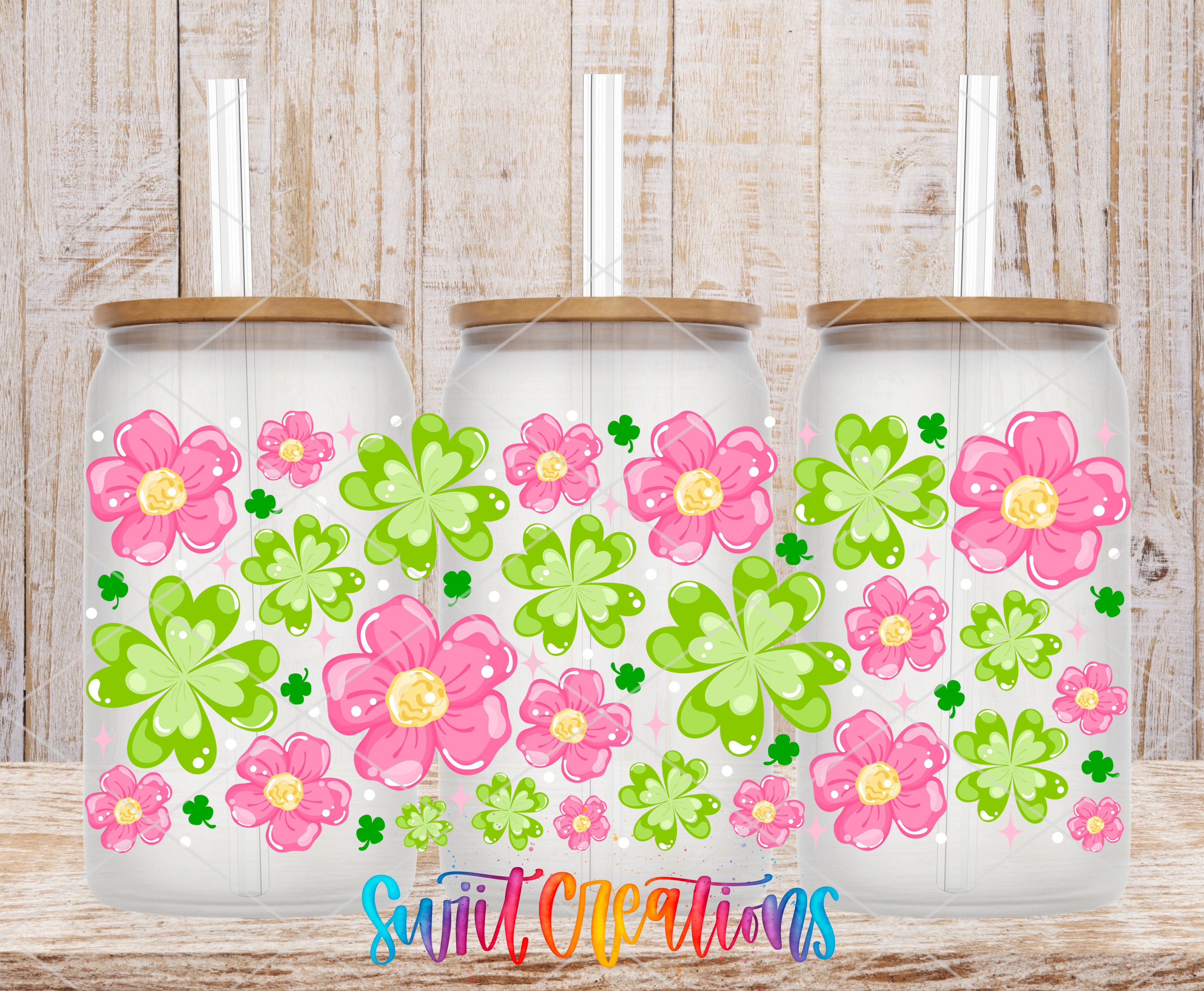 Three glass jars with flower designs on them, placed on a wooden surface.